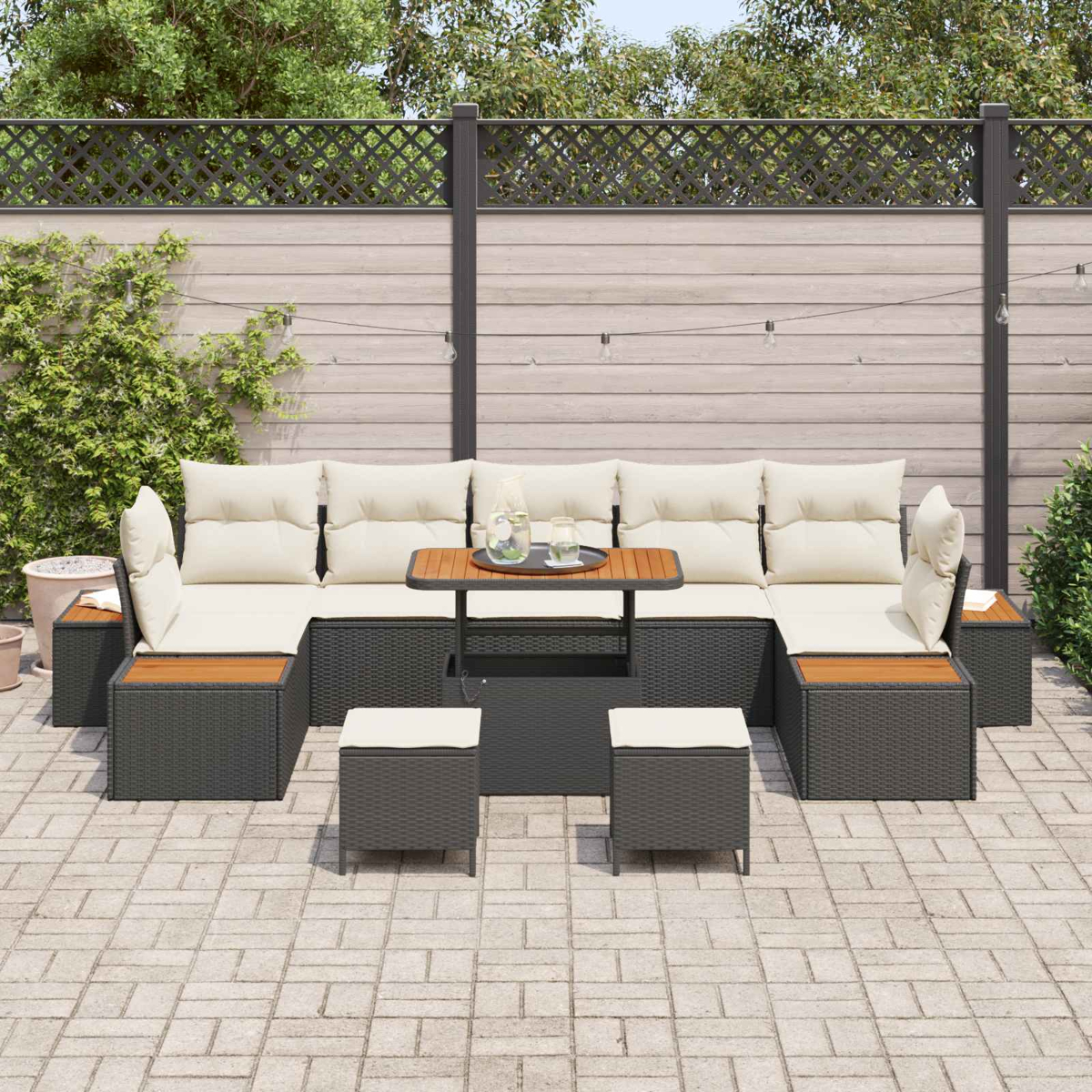 Ein dunkles Lounge-Set mit cremefarbenen Kissen auf einer gepflasterten Terrasse.