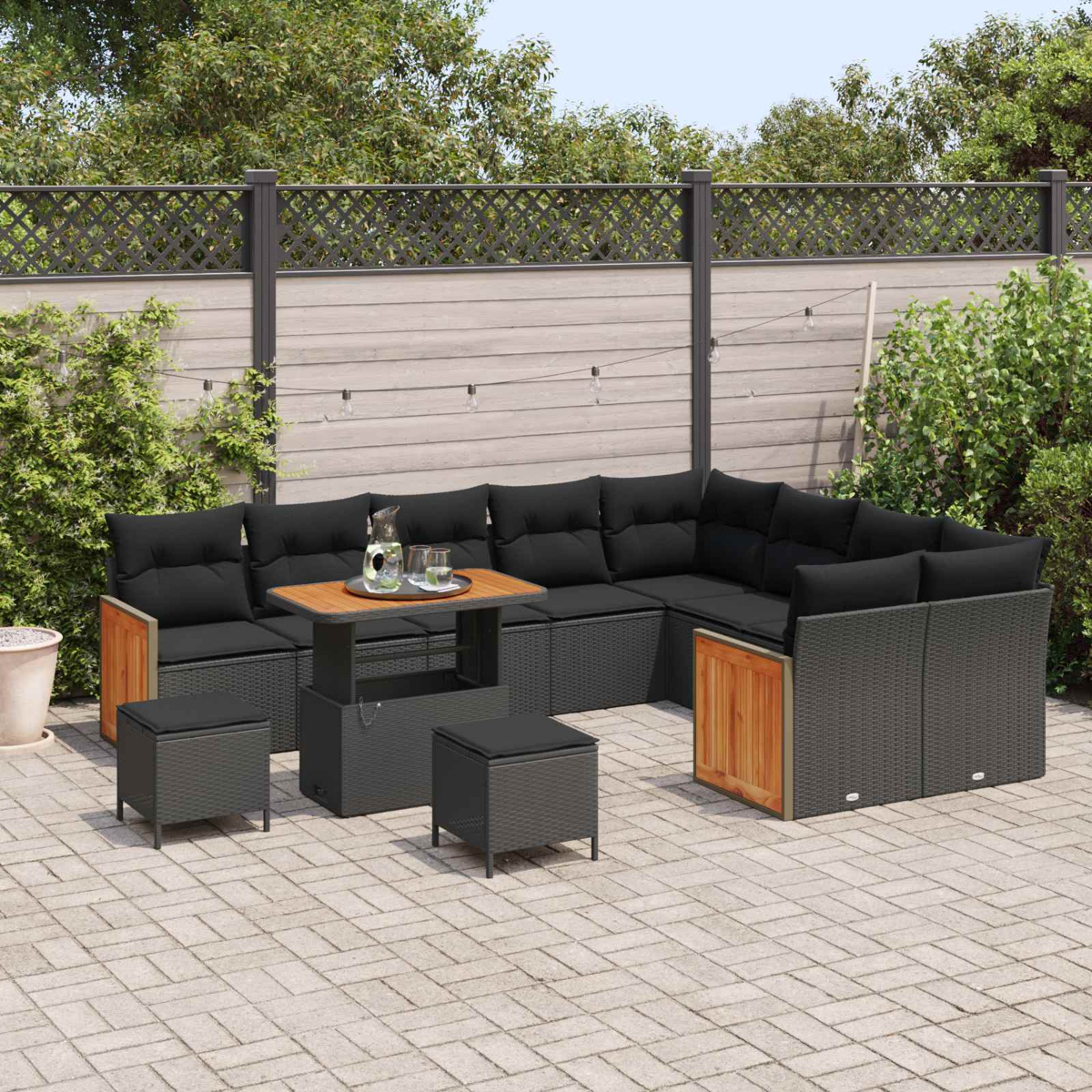 Outdoor-Ecksofa mit schwarzen Kissen und Holztisch auf einer Terrasse.
