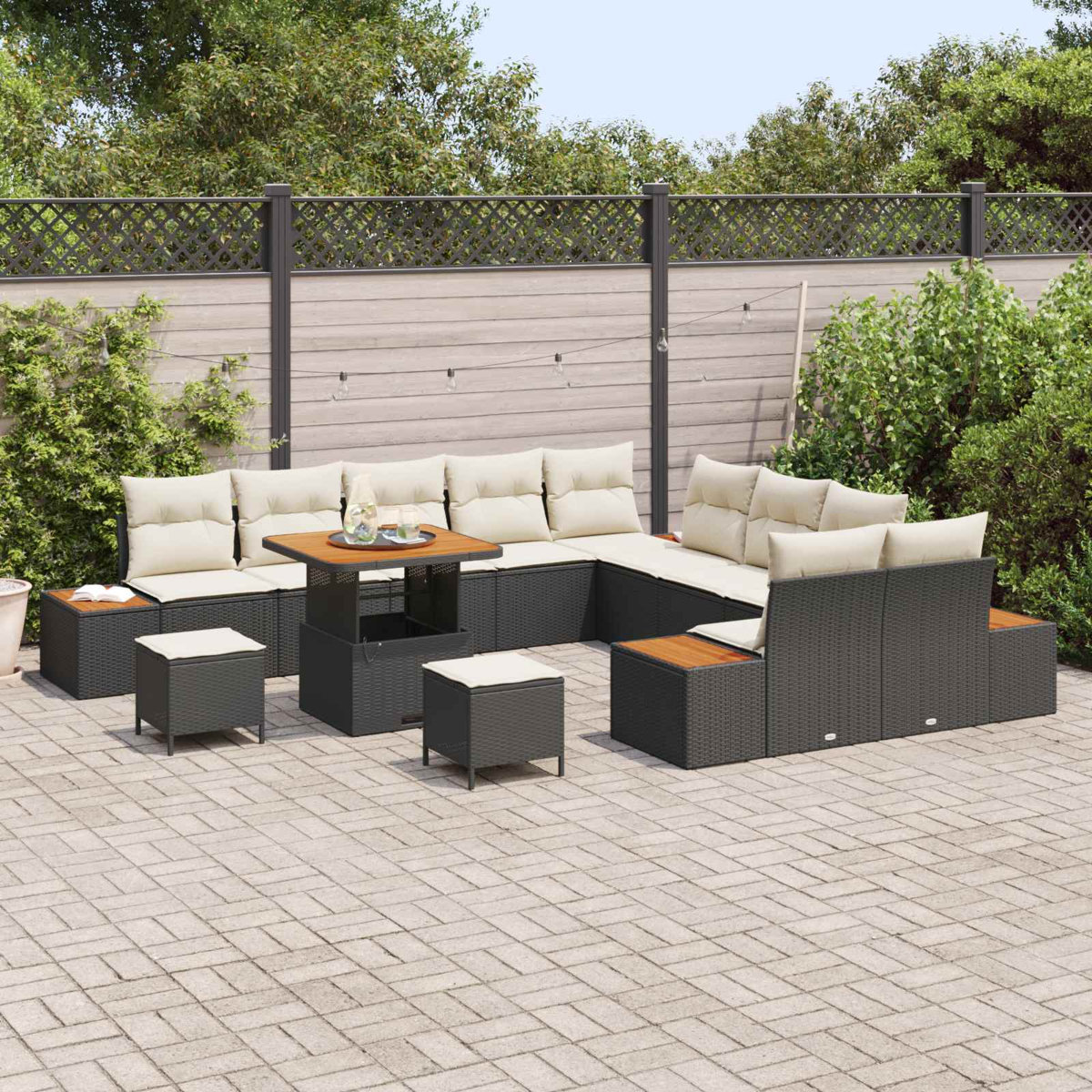 Divano componibile da esterno con cuscini crema e tavolo con piano in legno su patio pavimentato.