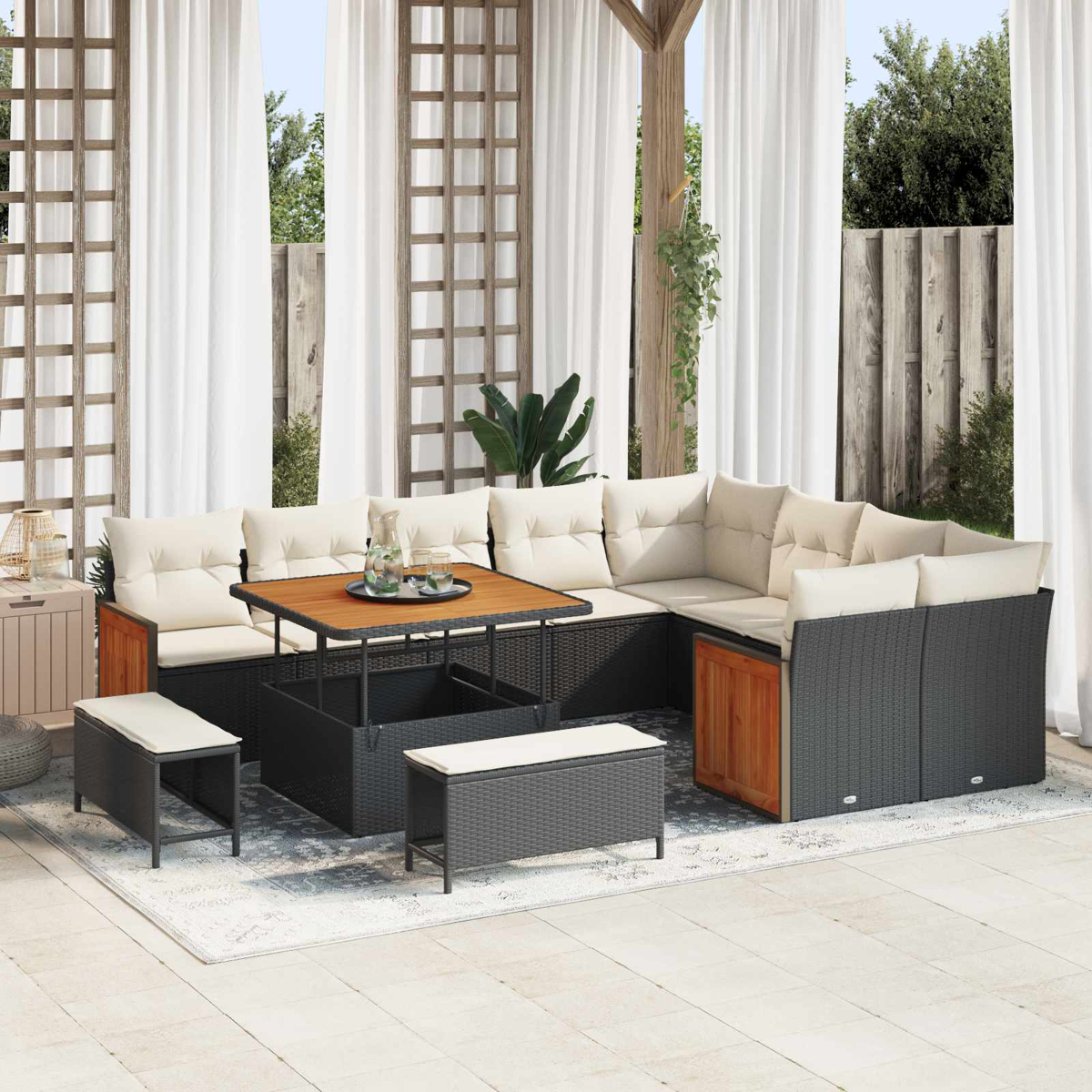Ein dunkles Gartensofa mit beigen Kissen steht auf einer Terrasse.