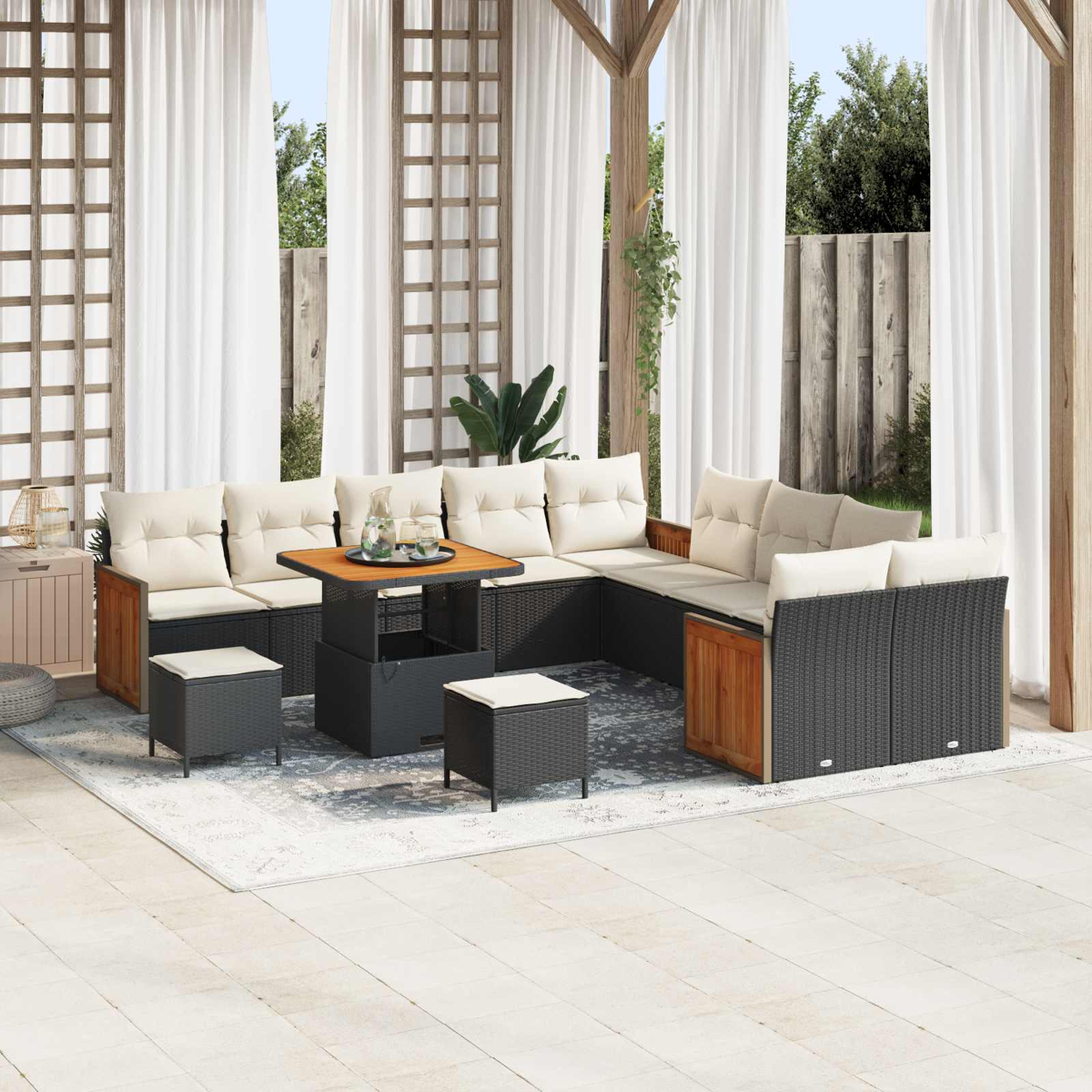 Ein dunkles Rattan-Lounge-Set mit hellbeigen Kissen unter einem Pavillon.