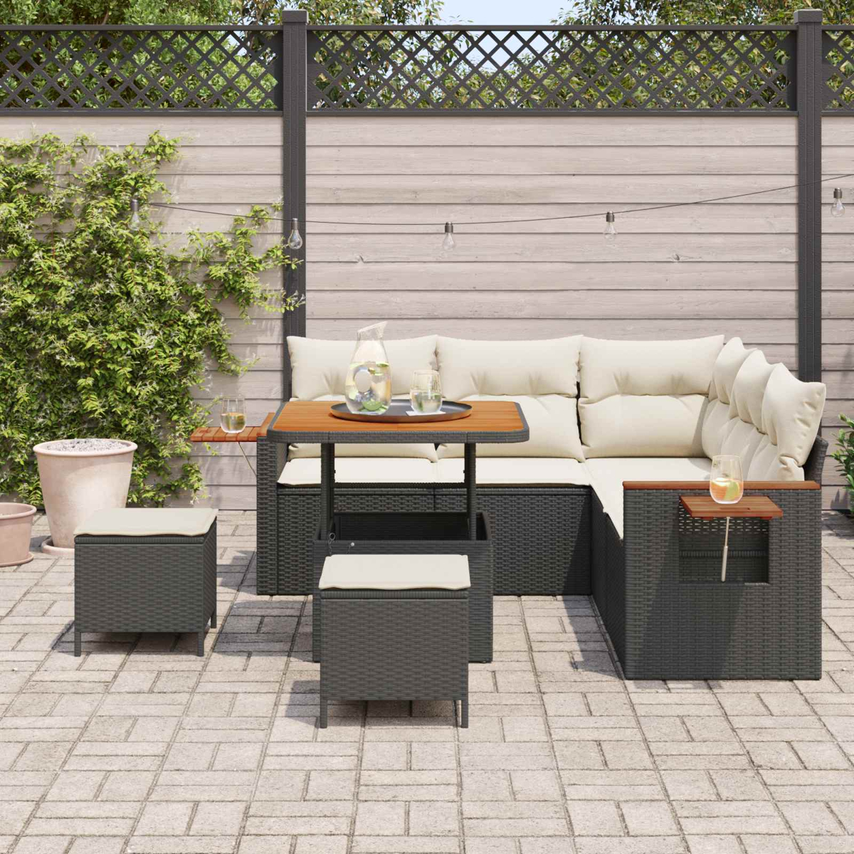 Ein graues Rattan-Ecksofa mit cremefarbenen Kissen und einem Holztisch.