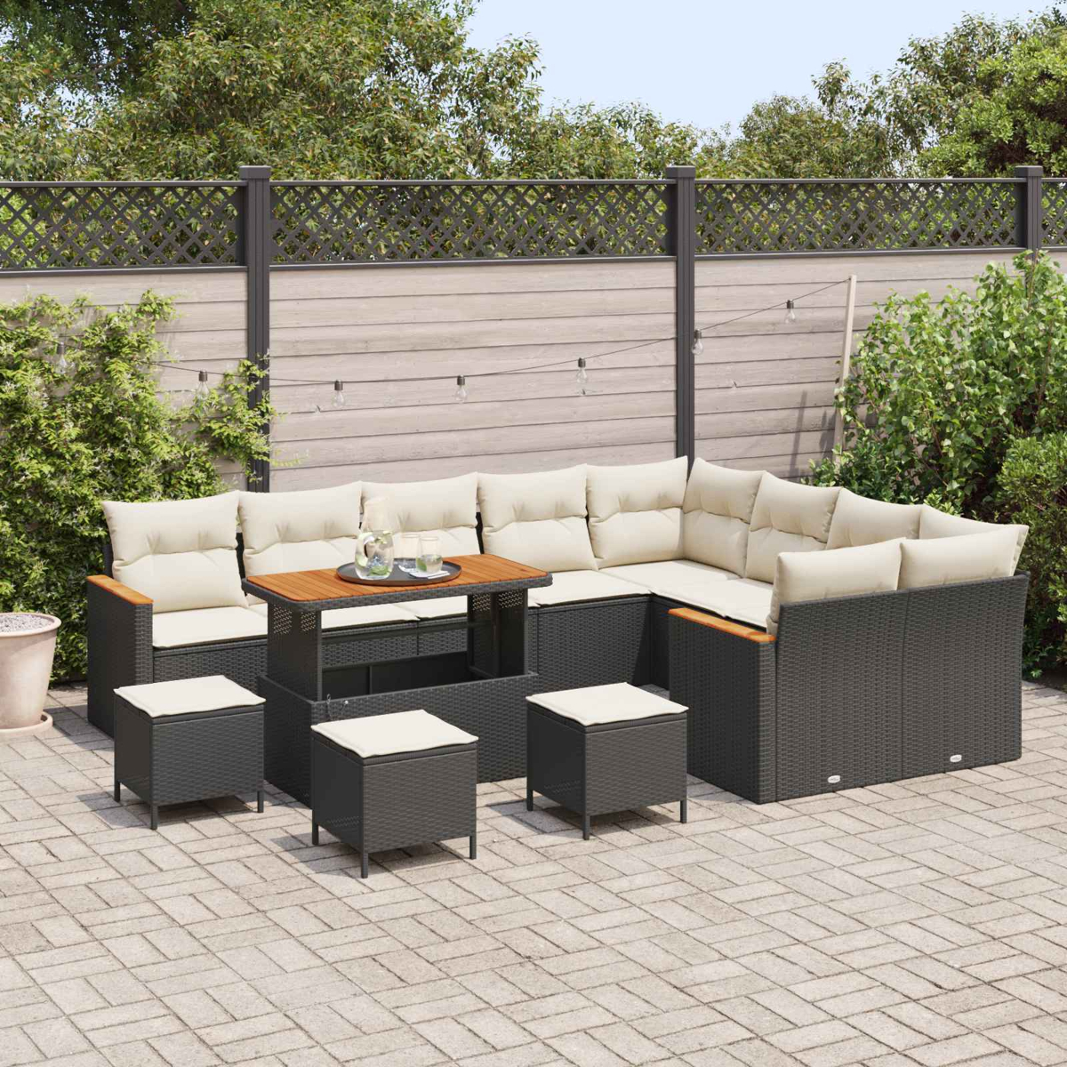 Un sofá seccional de mimbre oscuro con cojines beige y mesa de madera en patio pavimentado.