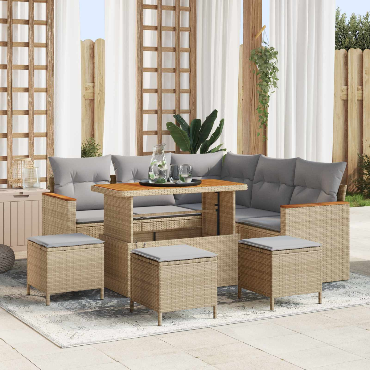 Conjunto de salón de mimbre con cojines grises y mesa de madera en un patio.