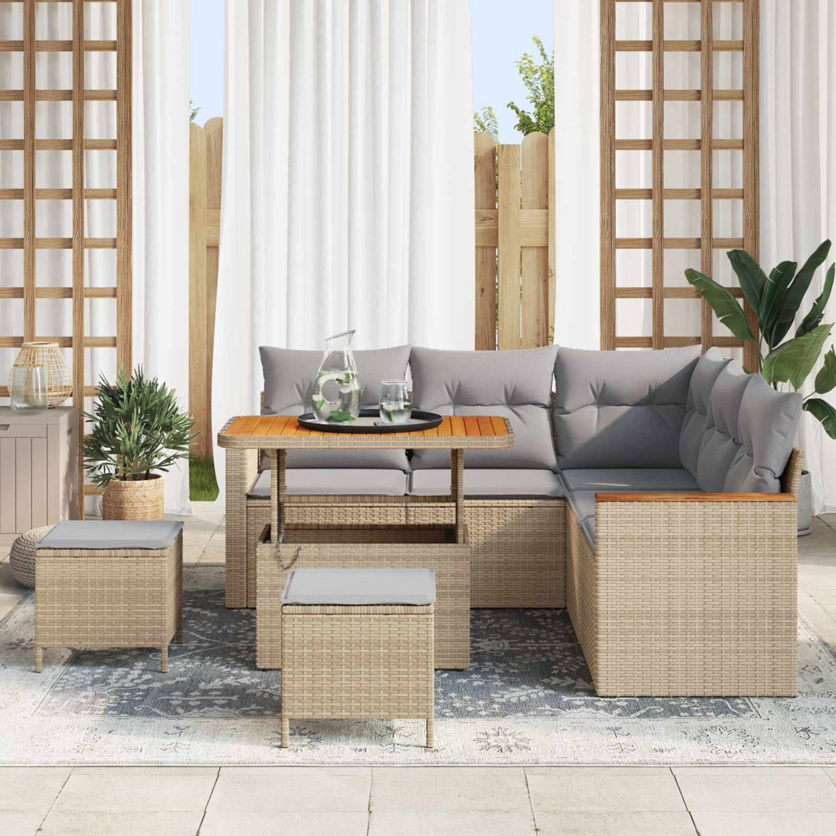 Geflochtenes Lounge-Set mit Kissen, Tisch mit Wasserkrug und Gläsern.