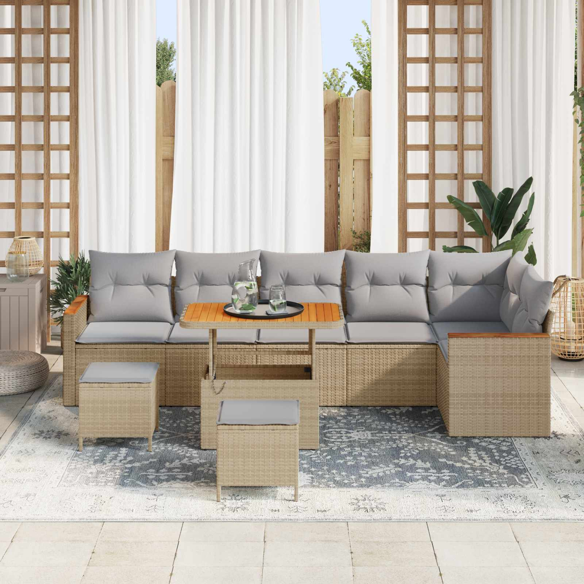 Ein beigefarbenes Rattan-Sofa mit grauen Kissen und einem Holztisch, draußen auf einer Terrasse.