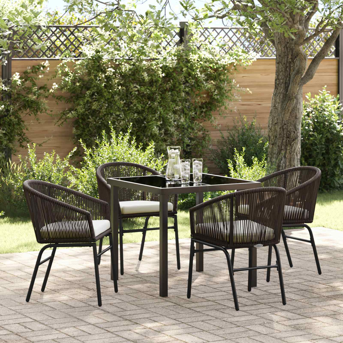 Ein dunkelbraunes Ess-Set aus Seil mit Glastisch und vier Stühlen auf einer Terrasse.