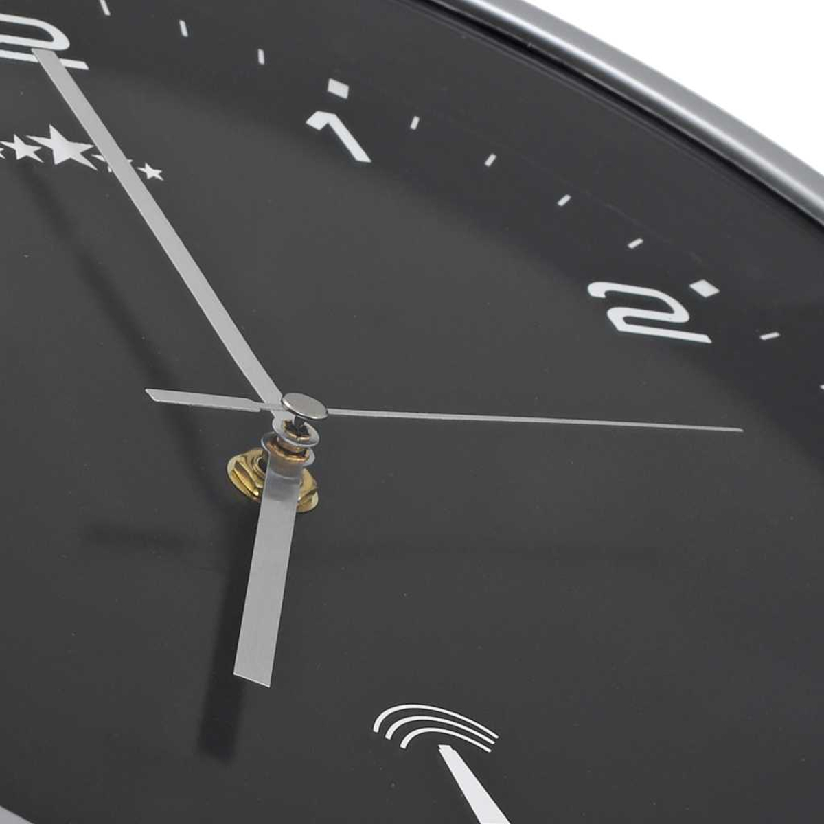 Nahaufnahme einer schwarzen Uhr mit silbernen Zeigern und Markierungen. Die Zeit ist ungefähr 1:55.