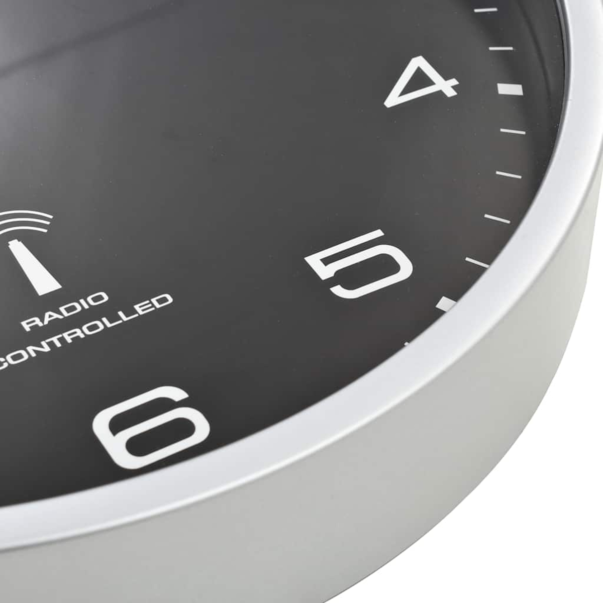 Nahaufnahme einer schwarzen Wanduhr mit silbernem Rahmen, Zahlen 4, 5, 6.