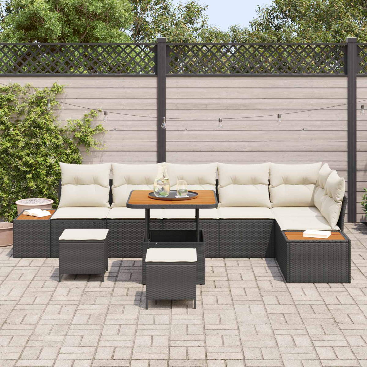 Ein dunkles Gartensofa mit cremefarbenen Kissen und einem kleinen Tisch.