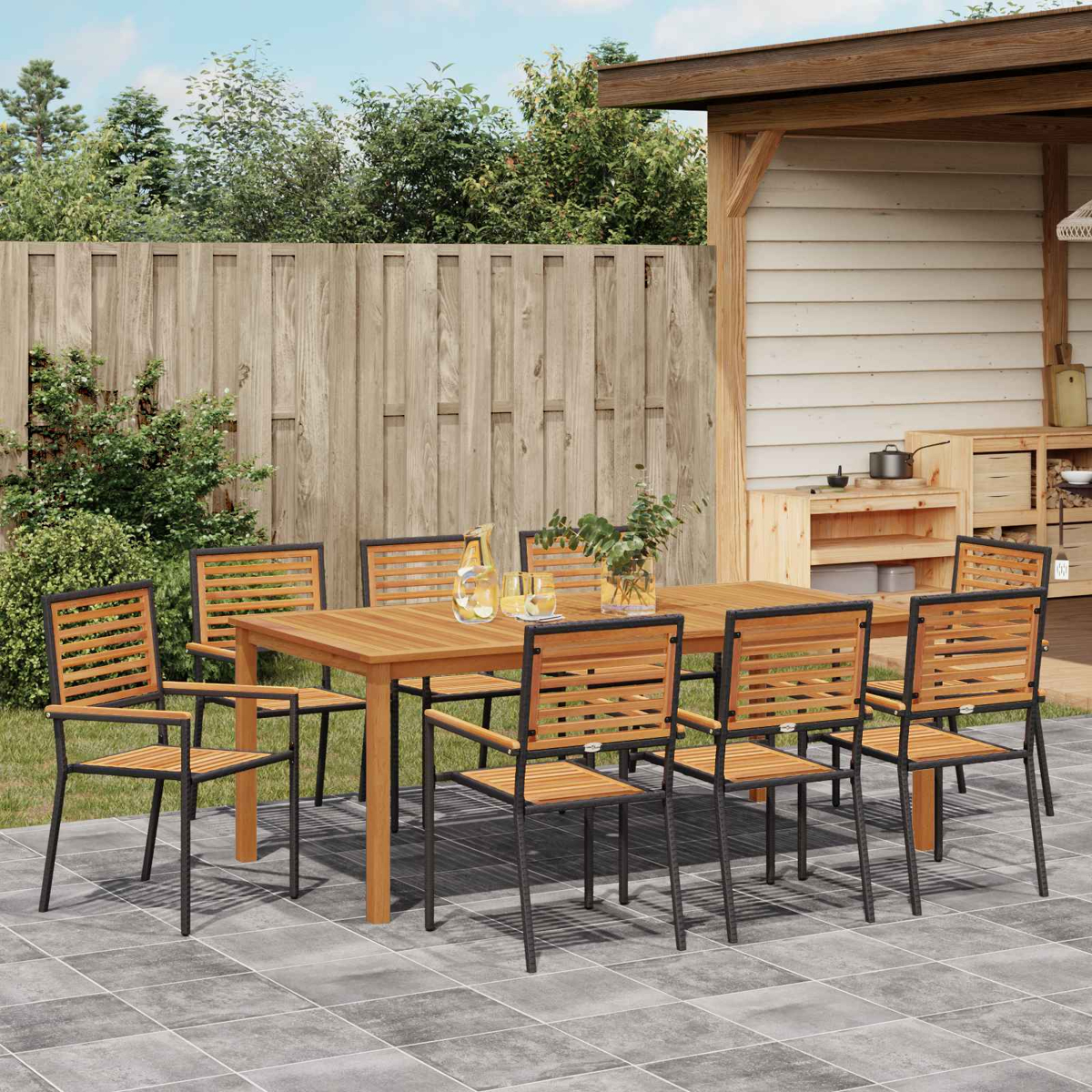 Un tavolo da pranzo in legno con sedie su un patio pavimentato.