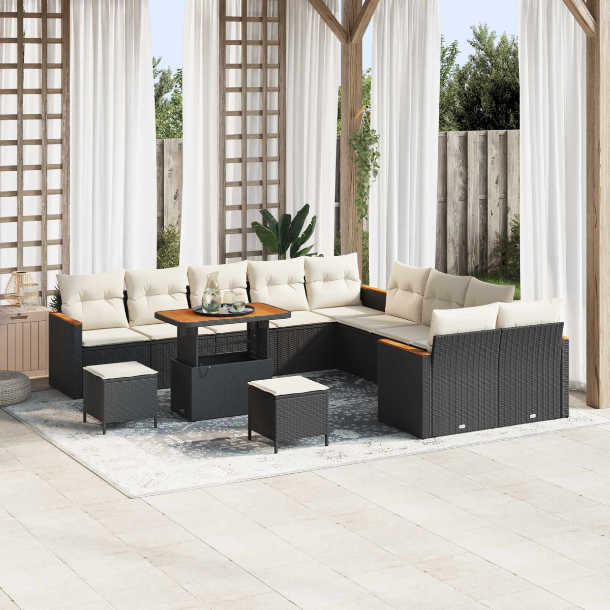 Ein schwarzes Rattan-Lounge-Set mit cremefarbenen Kissen auf einer Terrasse.