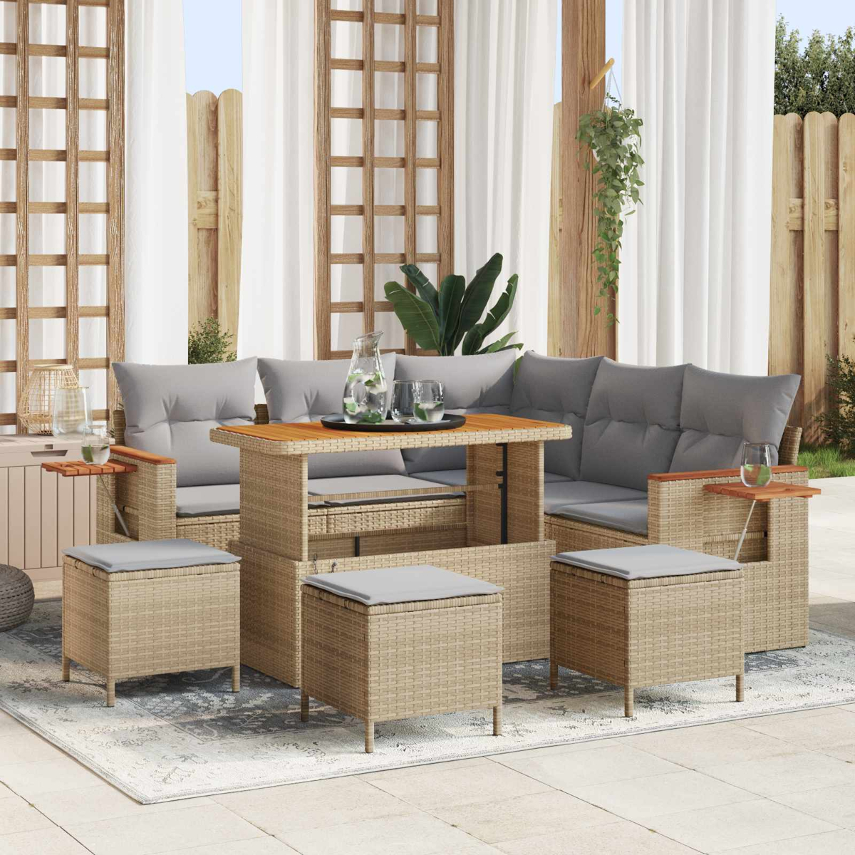 Ein beiger Rattansofa-Set mit grauen Kissen und einem Holztisch mit Gläsern.
