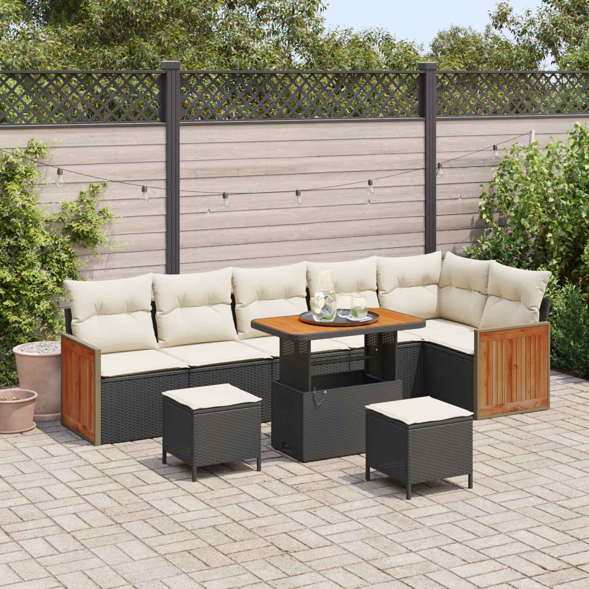 Outdoor-Ecksofa mit beigen Kissen, einem Couchtisch mit Hubplatte und zwei Hockern auf einer gepflasterten Terrasse.