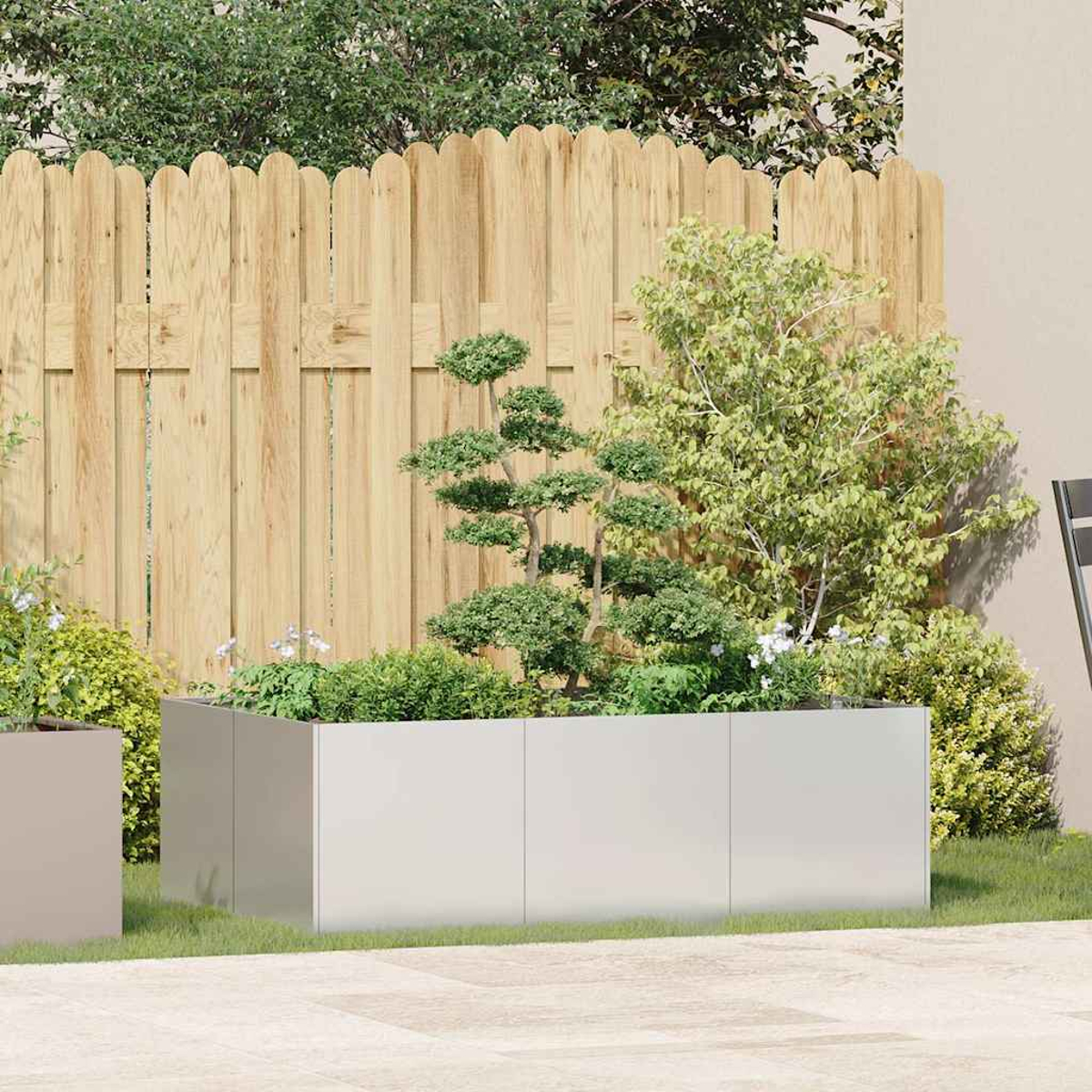 Un giardino moderno con una lunga fioriera piena di piante verdi e un bonsai.
