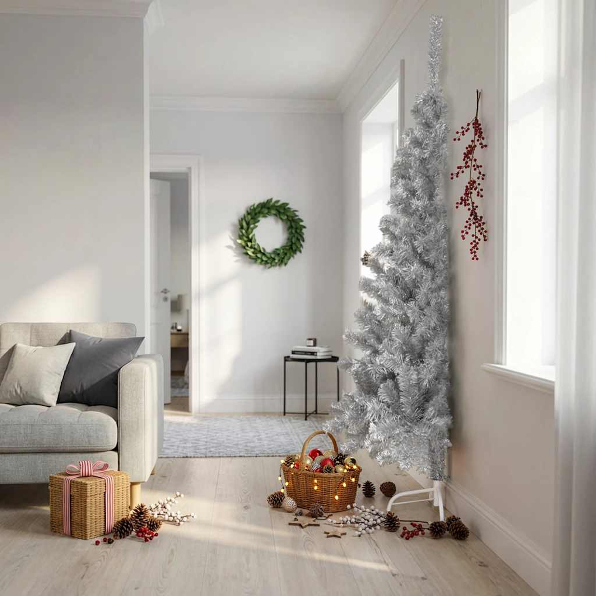 Ein silberner Weihnachtsbaum steht neben einem Fenster, mit Geschenken und Dekorationen.