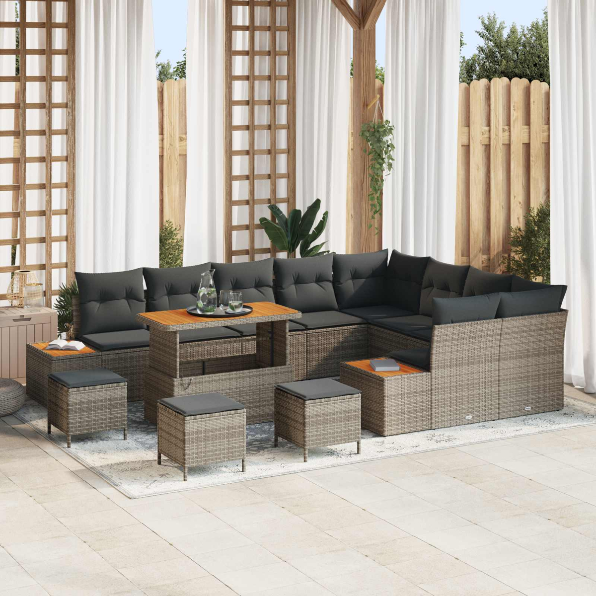 Geflochtene Lounge-Möbel mit grauen Kissen und Holztisch auf einer Terrasse.