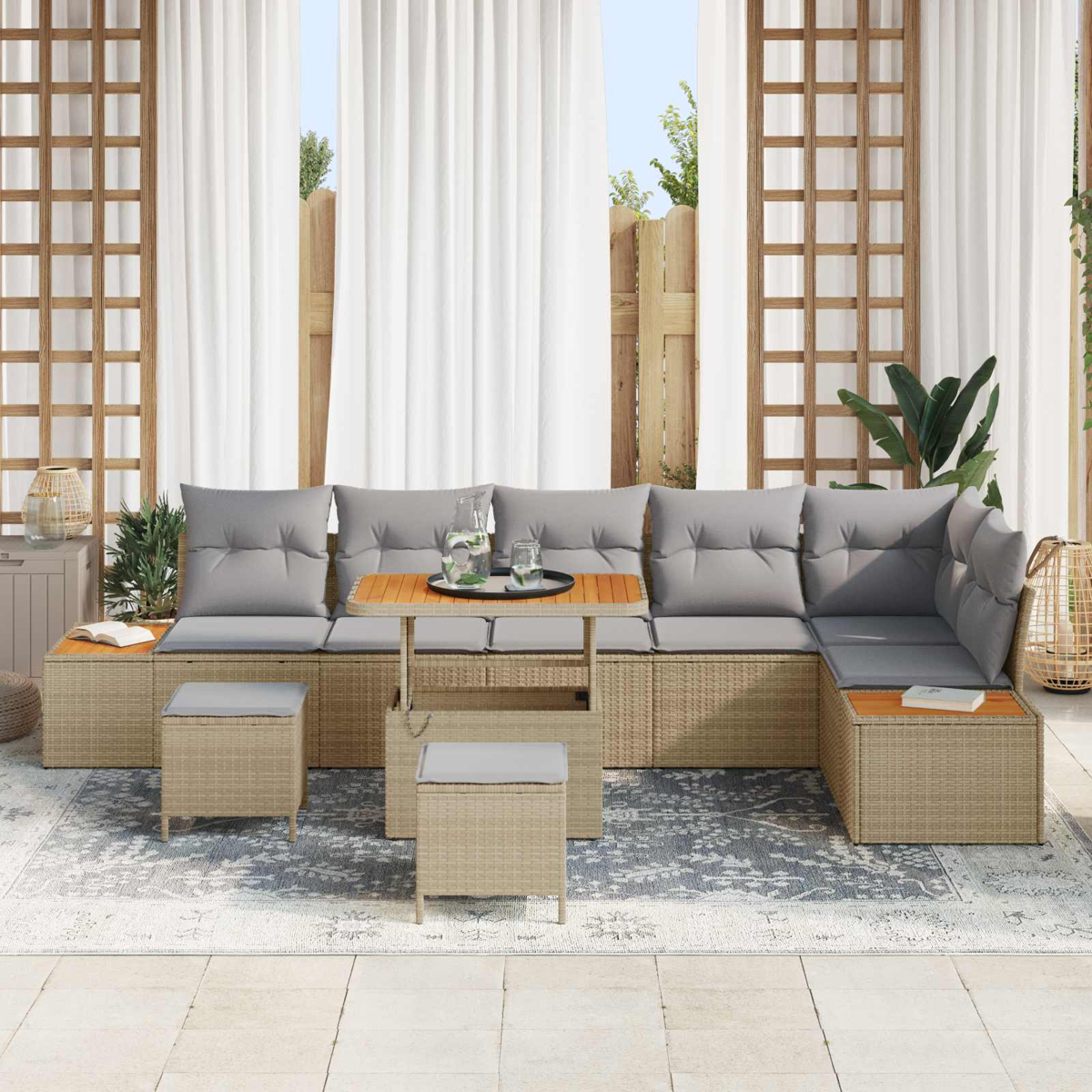Beigefarbene Rattan-Lounge mit grauen Kissen und Holztisch auf einer Terrasse.