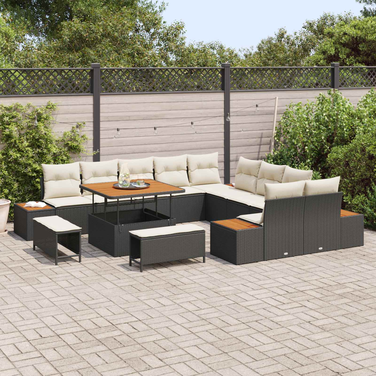 Gartenmöbel-Set aus dunklem Rattan mit hellbeigen Kissen und einem Holztisch.