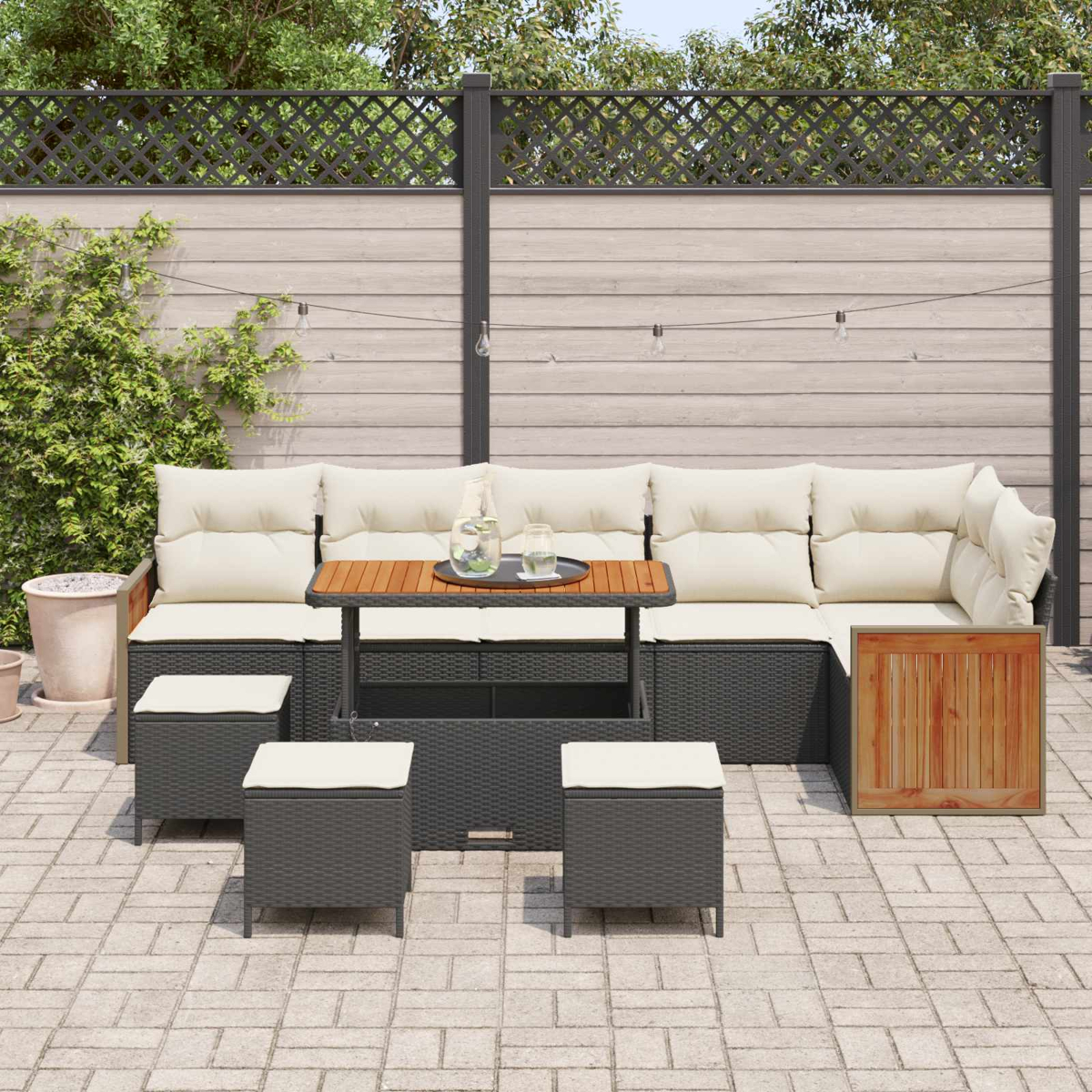 Outdoor-Sofa mit cremefarbenen Kissen, Couchtisch und Hockern auf gepflasterter Terrasse.
