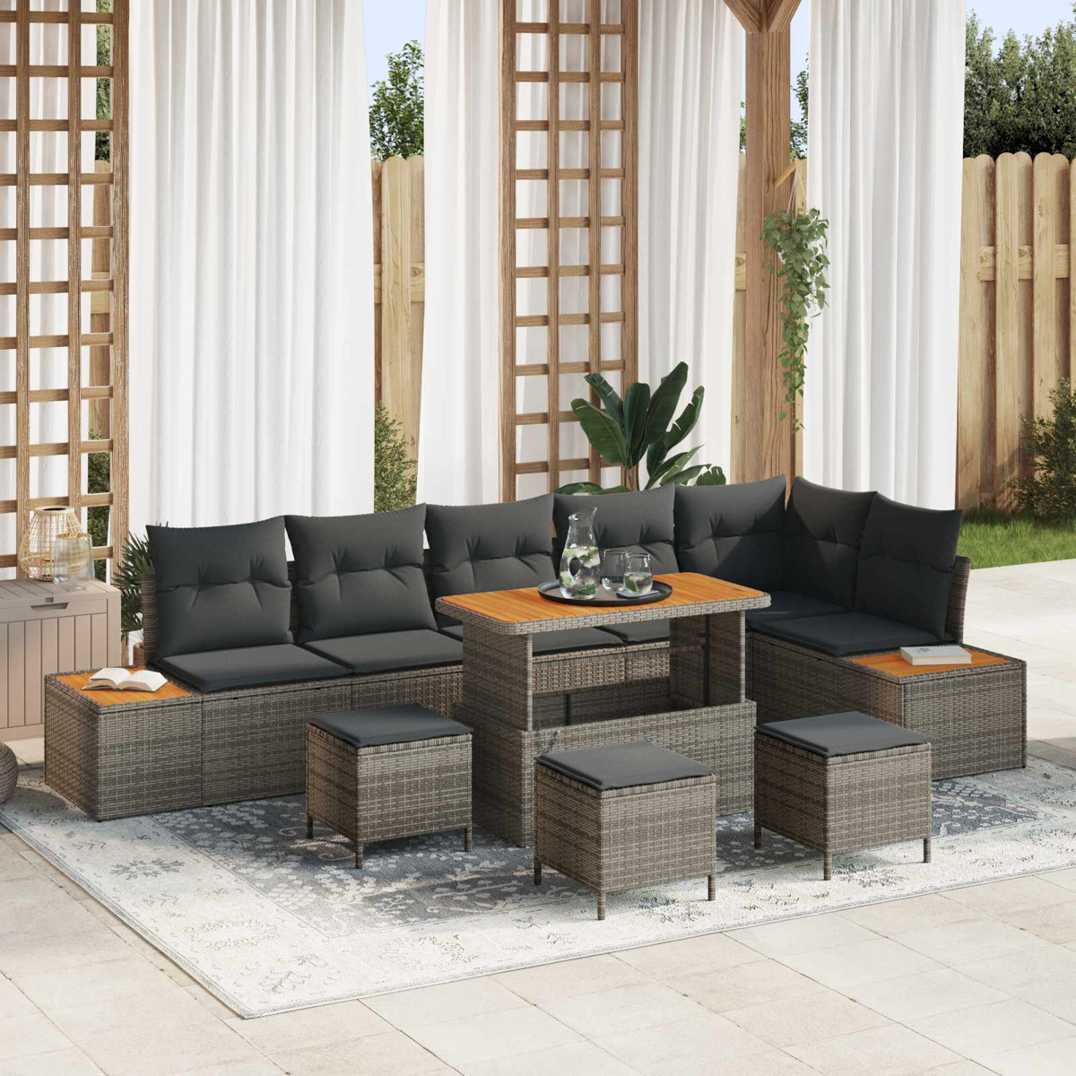 Graue Outdoor-Lounge-Möbel mit Tisch, Hockern und Kissen auf einer Terrasse.