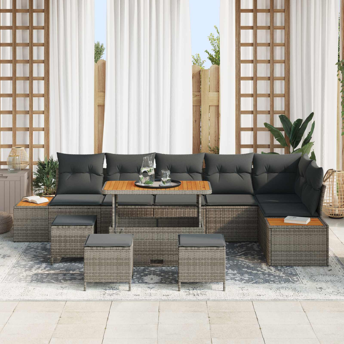 Graues Lounge-Set mit Tisch, Hockern und Kissen auf einer Terrasse.