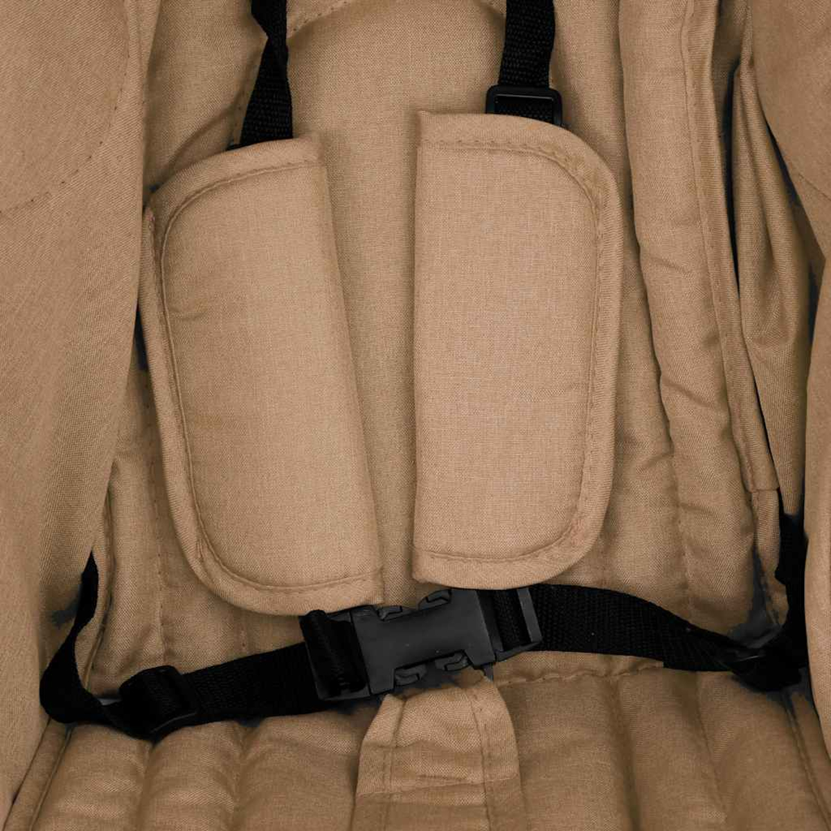 Nahaufnahme eines beige gepolsterten Kinderwagensitzes mit schwarzen Gurten und Schnalle.