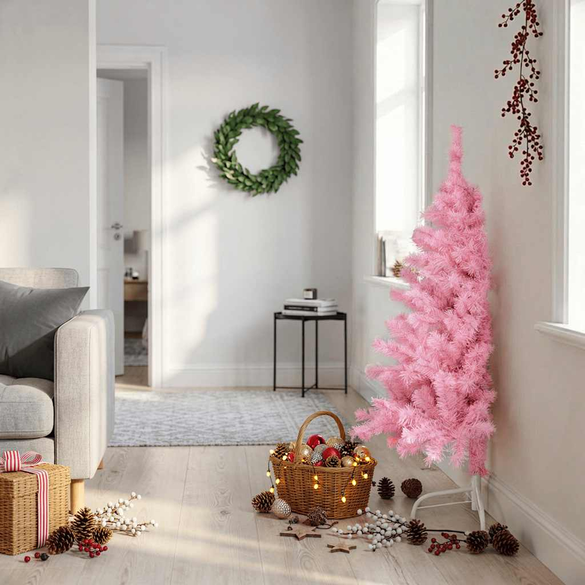 Ein pinker Weihnachtsbaum steht neben einem Korb mit Lichtern und Ornamenten. Ein Kranz hängt an der Wand.