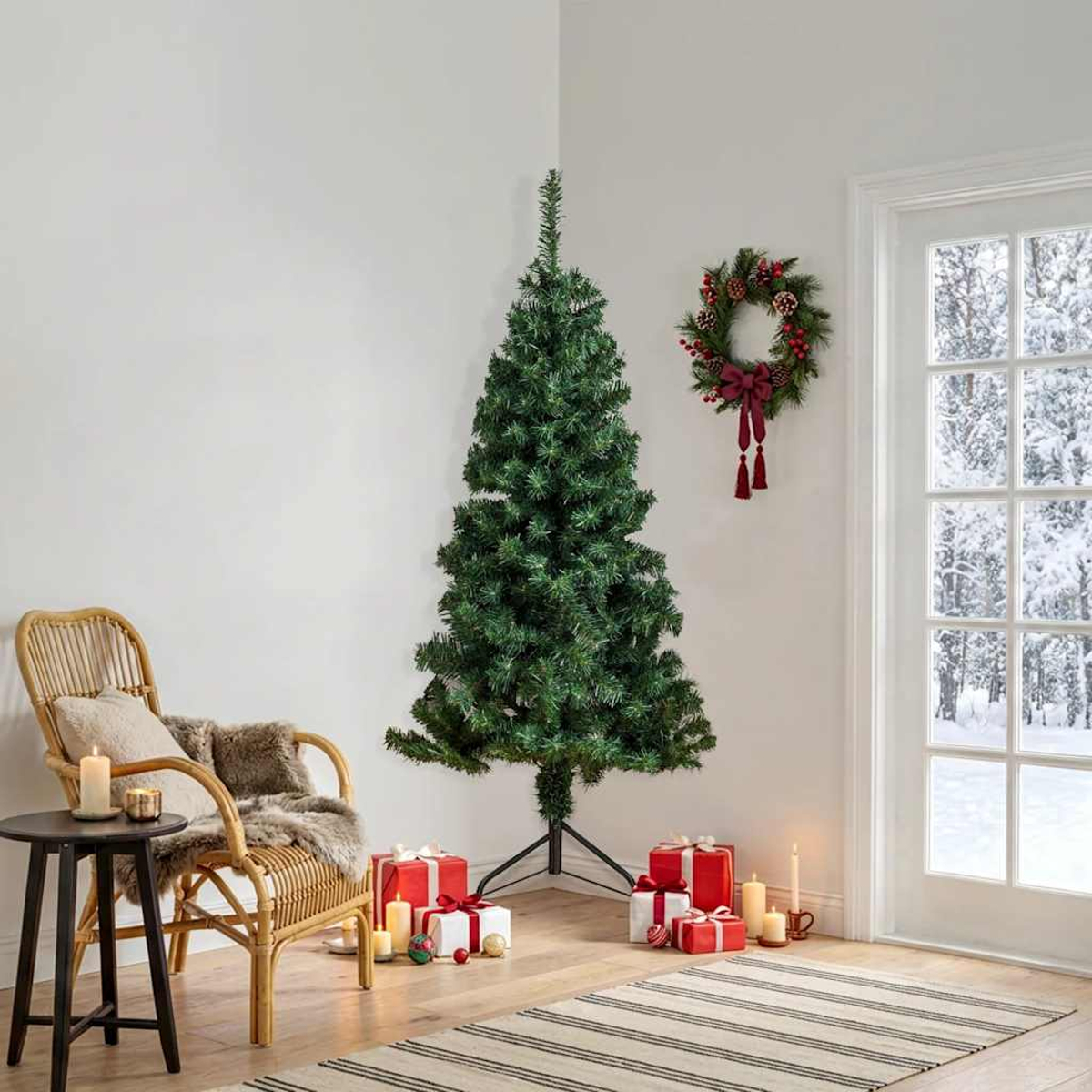 Ein grüner Weihnachtsbaum steht neben einem Korbstuhl mit Geschenken und Kerzen. Ein Kranz hängt an der Wand.