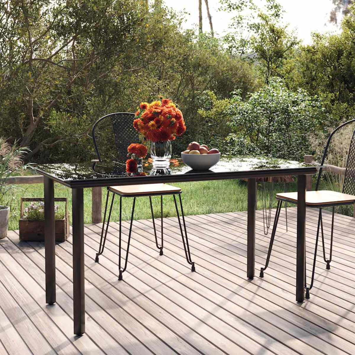 Ein Gartentisch mit Blumen und Obst, auf einer Holzterrasse.