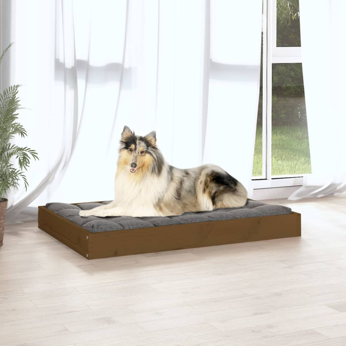 Ein Collie-Hund liegt auf einem braunen Holz-Hundebett mit grauer Polsterung.