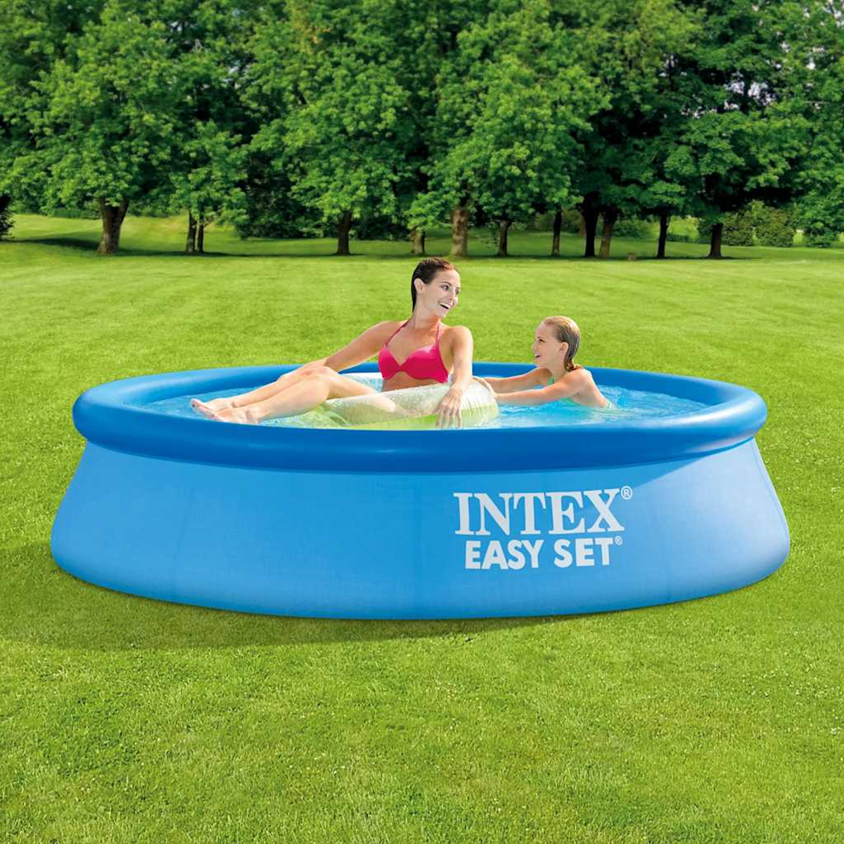 Due donne si rilassano in una piscina blu Intex Easy Set su un prato verde con alberi dietro.
