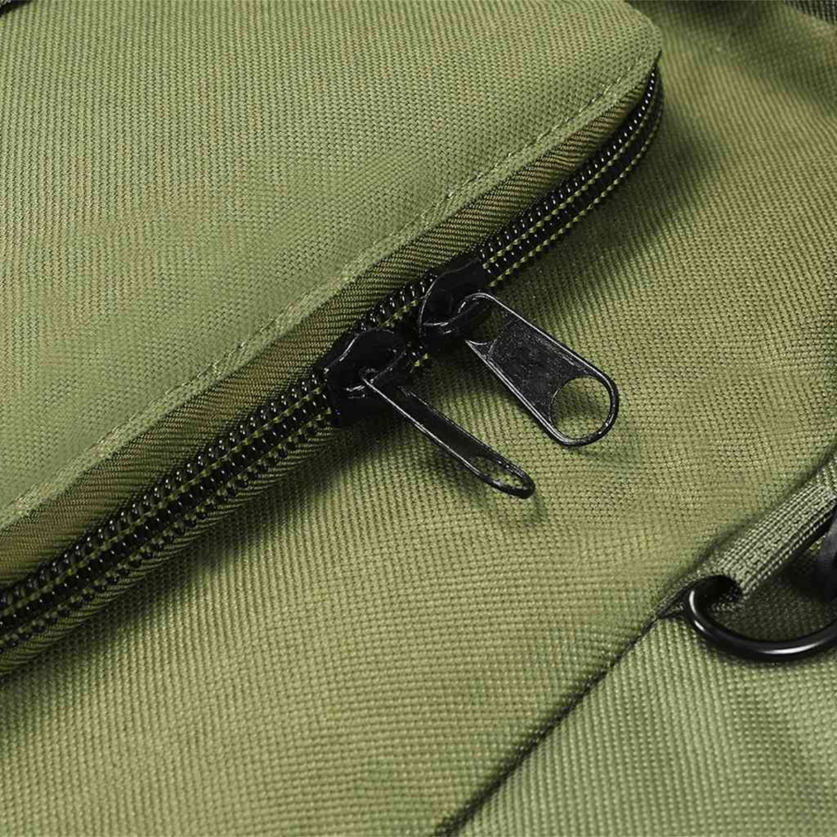 Grüne Stofftasche mit schwarzen Reißverschlüssen und einem Ring.
