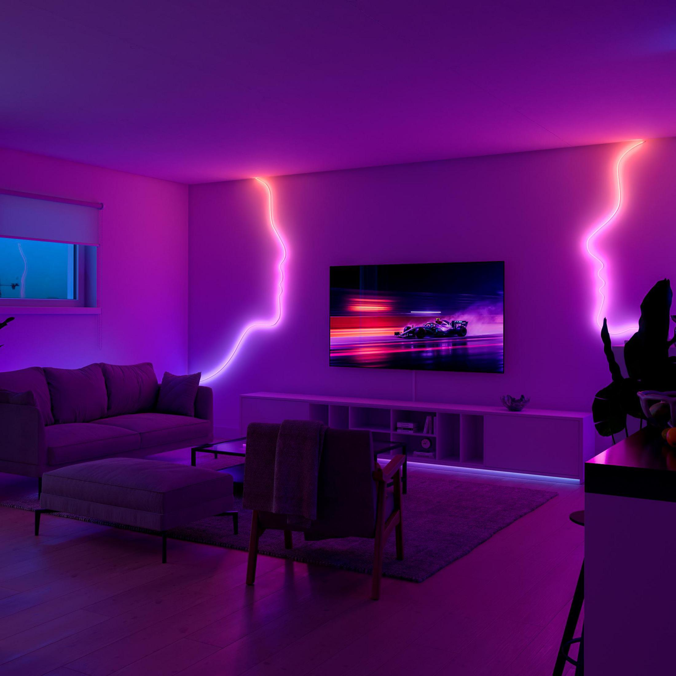 Un soggiorno con illuminazione viola, un divano, una TV e una grafica di auto da corsa.