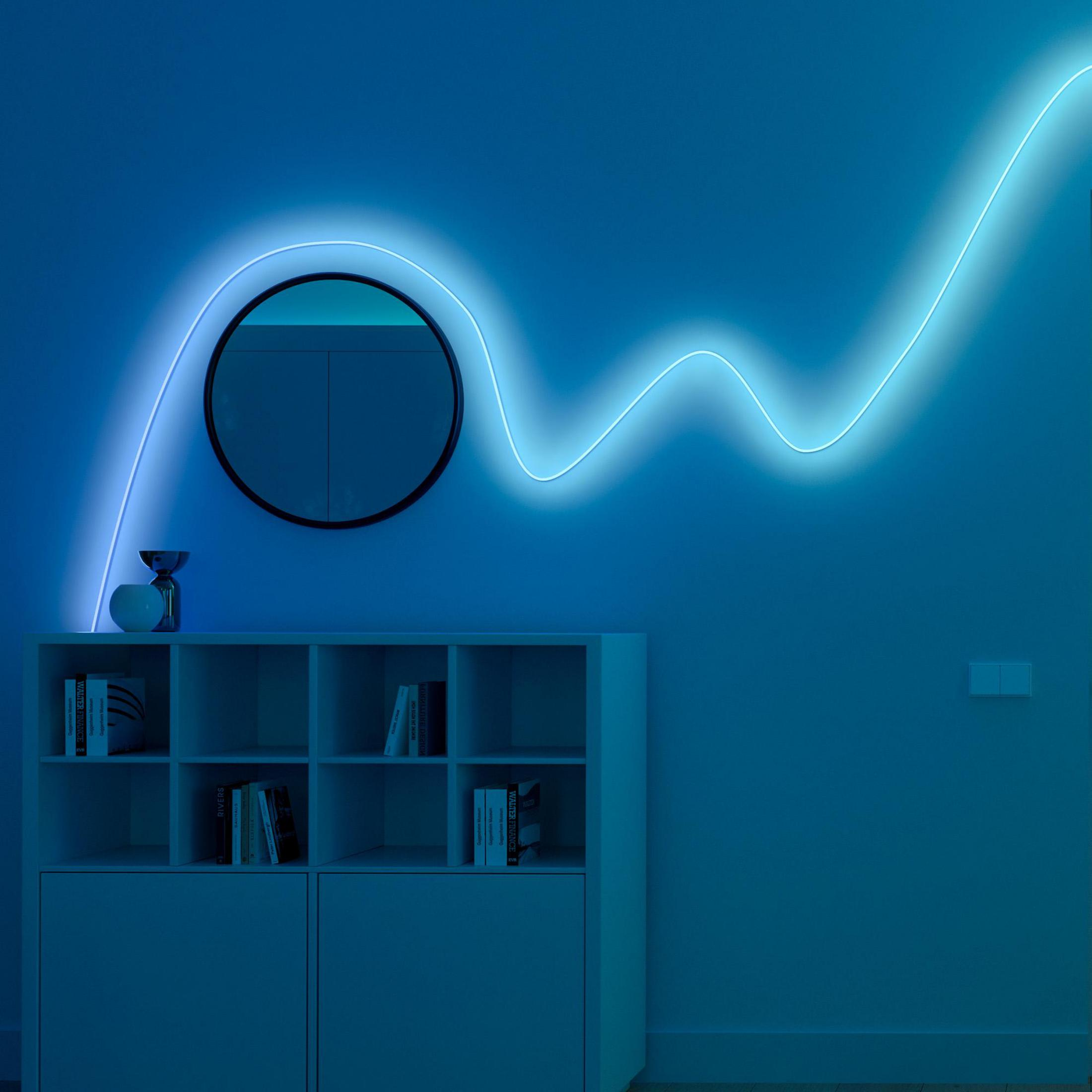 Un tubo al neon blu serpeggia su una mensola con specchio e decorazioni.
