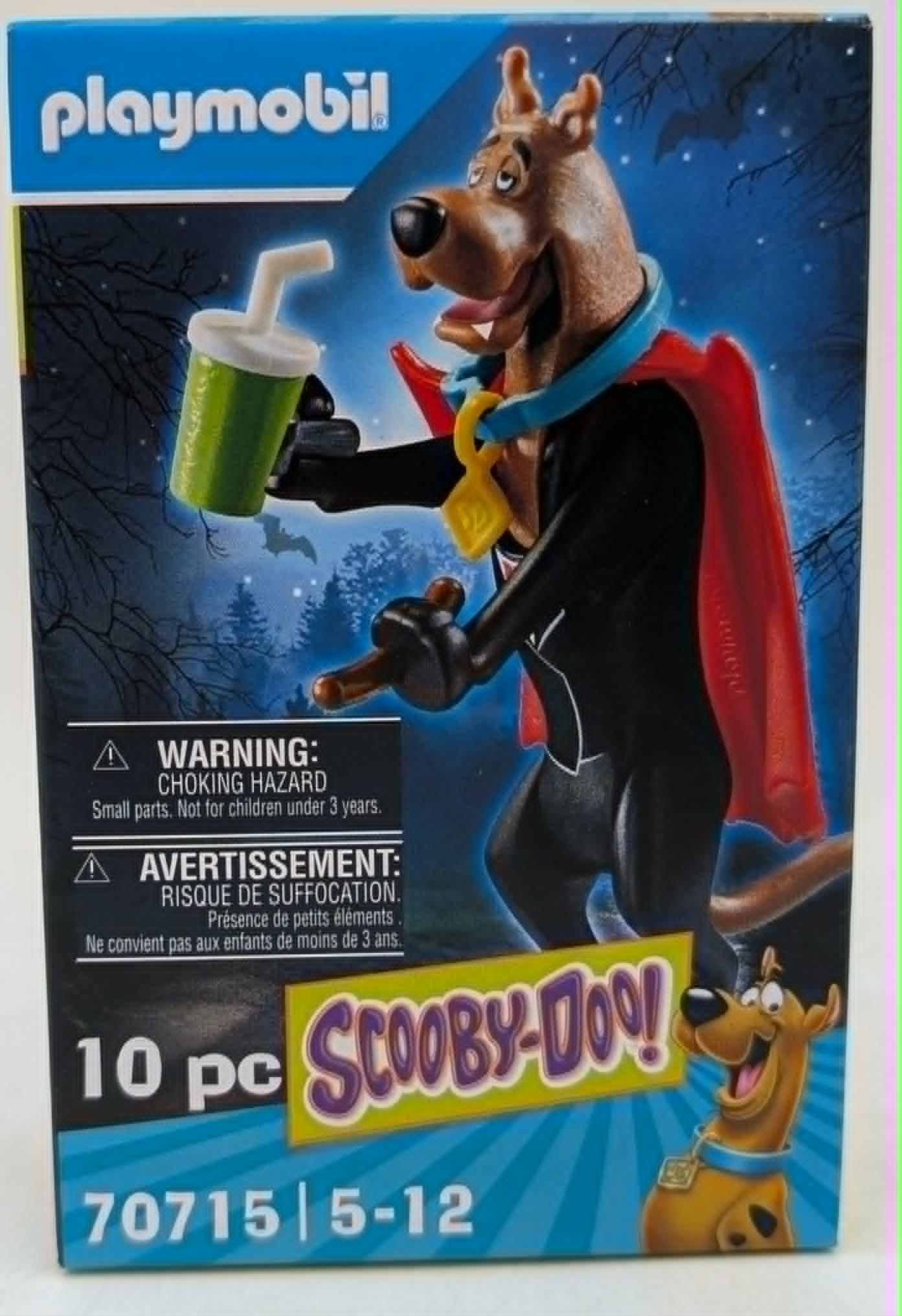 Personaggio Playmobil Scooby-Doo con mantello rosso e bicchiere verde, scena notturna.