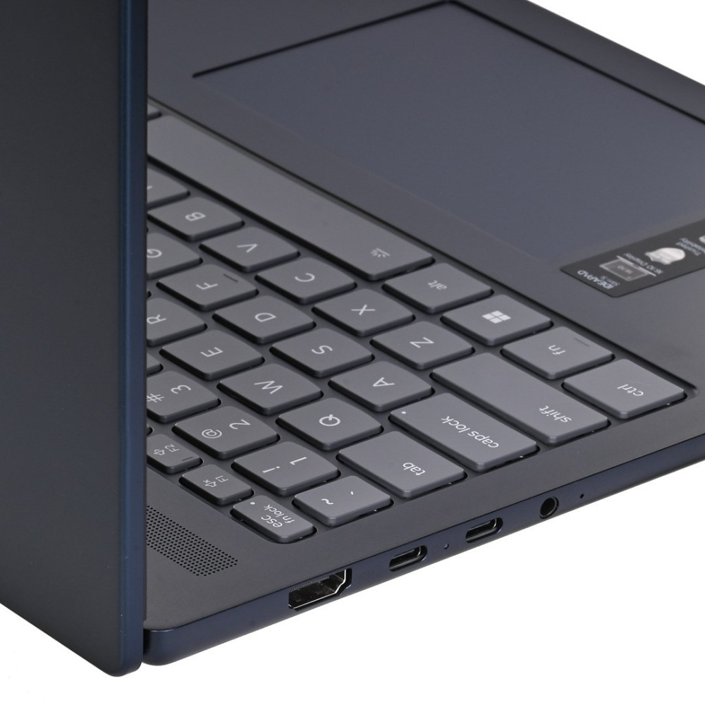 Ciemnoniebieska klawiatura i touchpad laptopa z portami z boku.