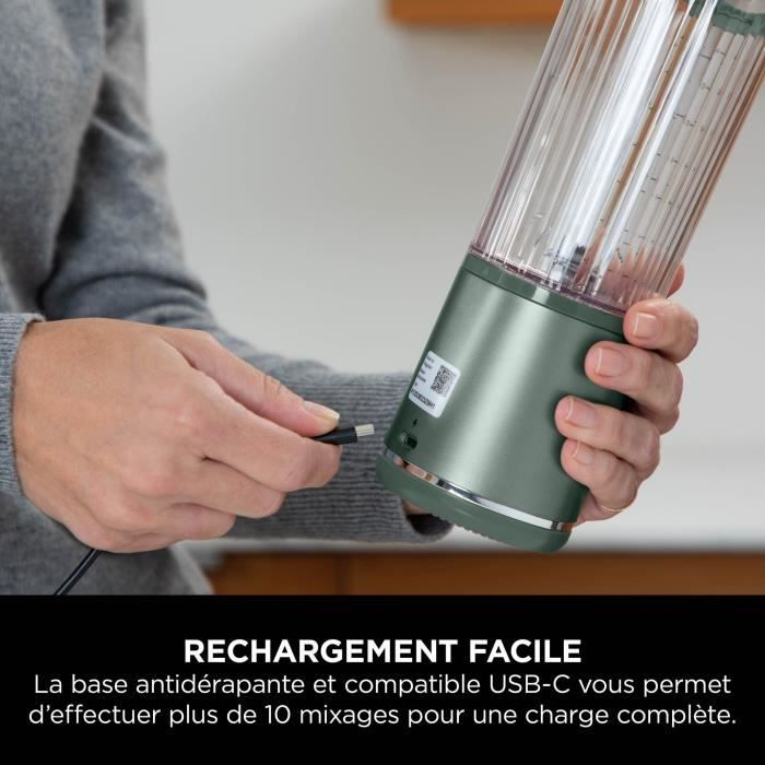 Una persona carica un frullatore portatile tramite USB-C. Il frullatore è verde e trasparente.