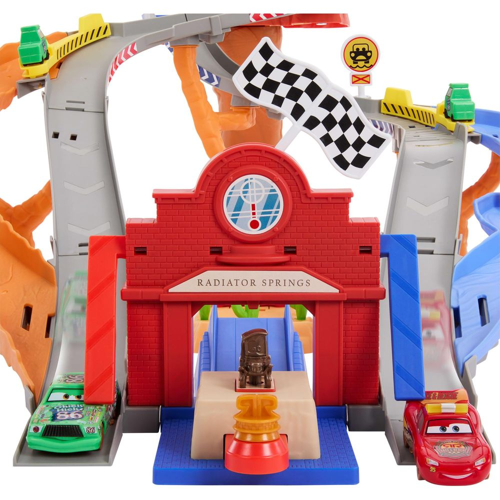 Un juego de pistas de carreras de Radiator Springs de juguete con coches y banderas.