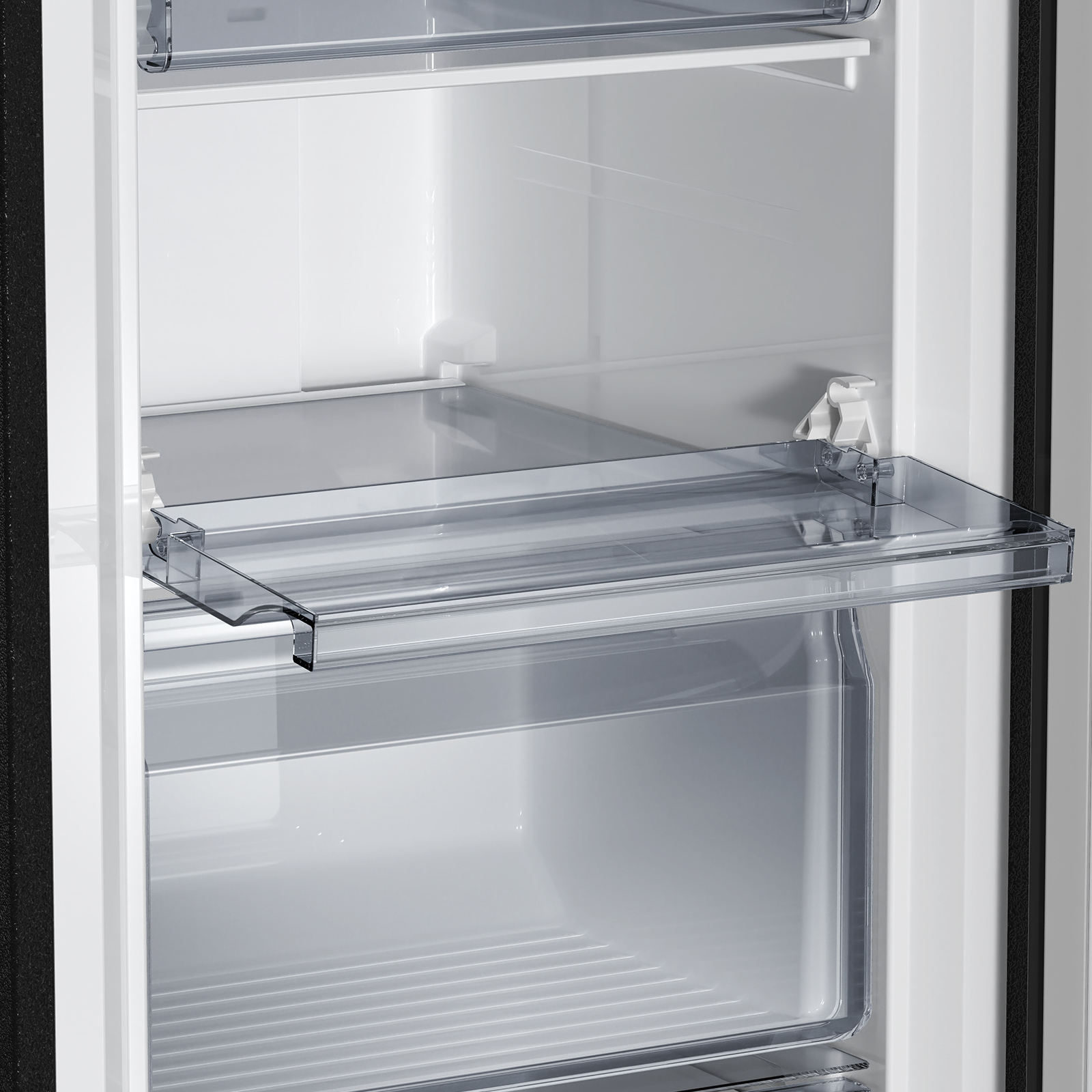 Un compartimento transparente de refrigerador con paredes blancas y fondo de rejilla.