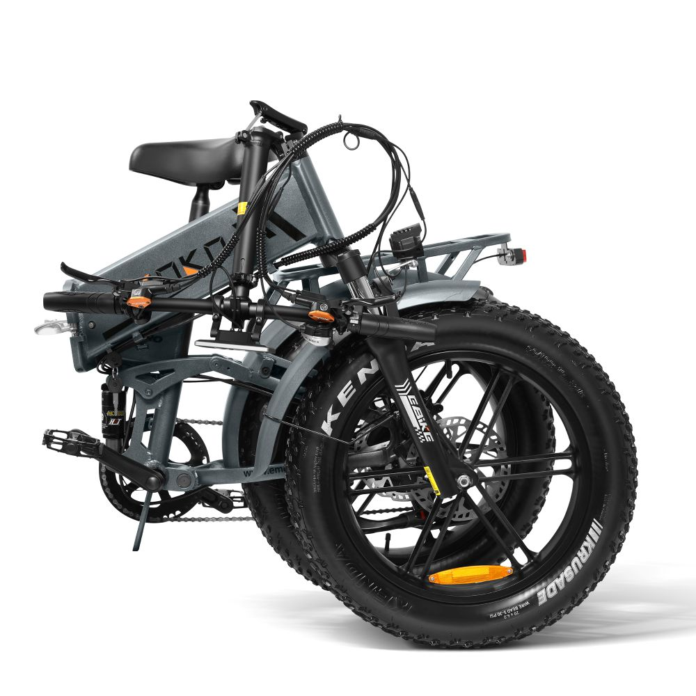 Bicicleta eléctrica plegable gris con neumáticos anchos, manillar, asiento y pedales.