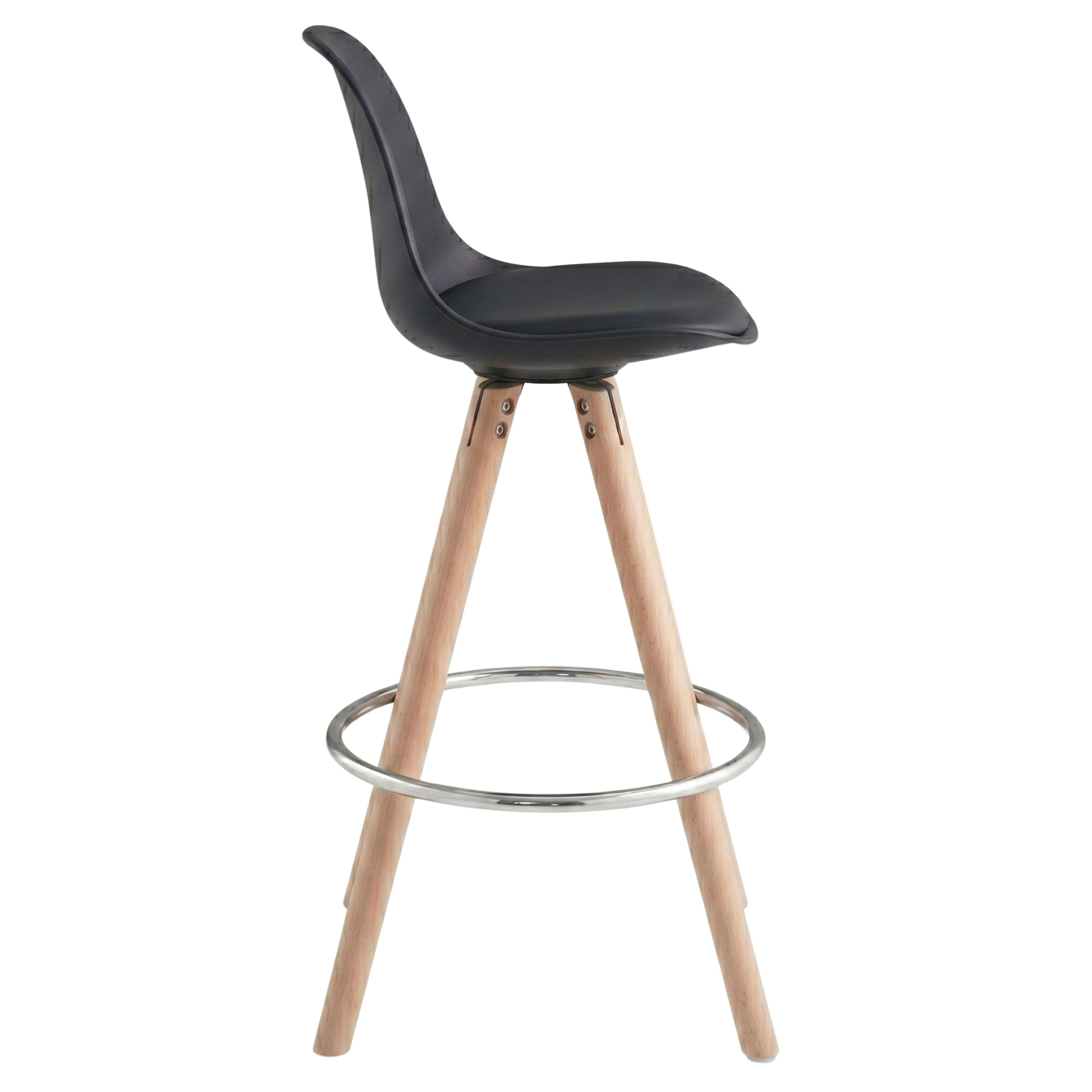 Taburete de bar negro con patas de madera y reposapiés metálico.