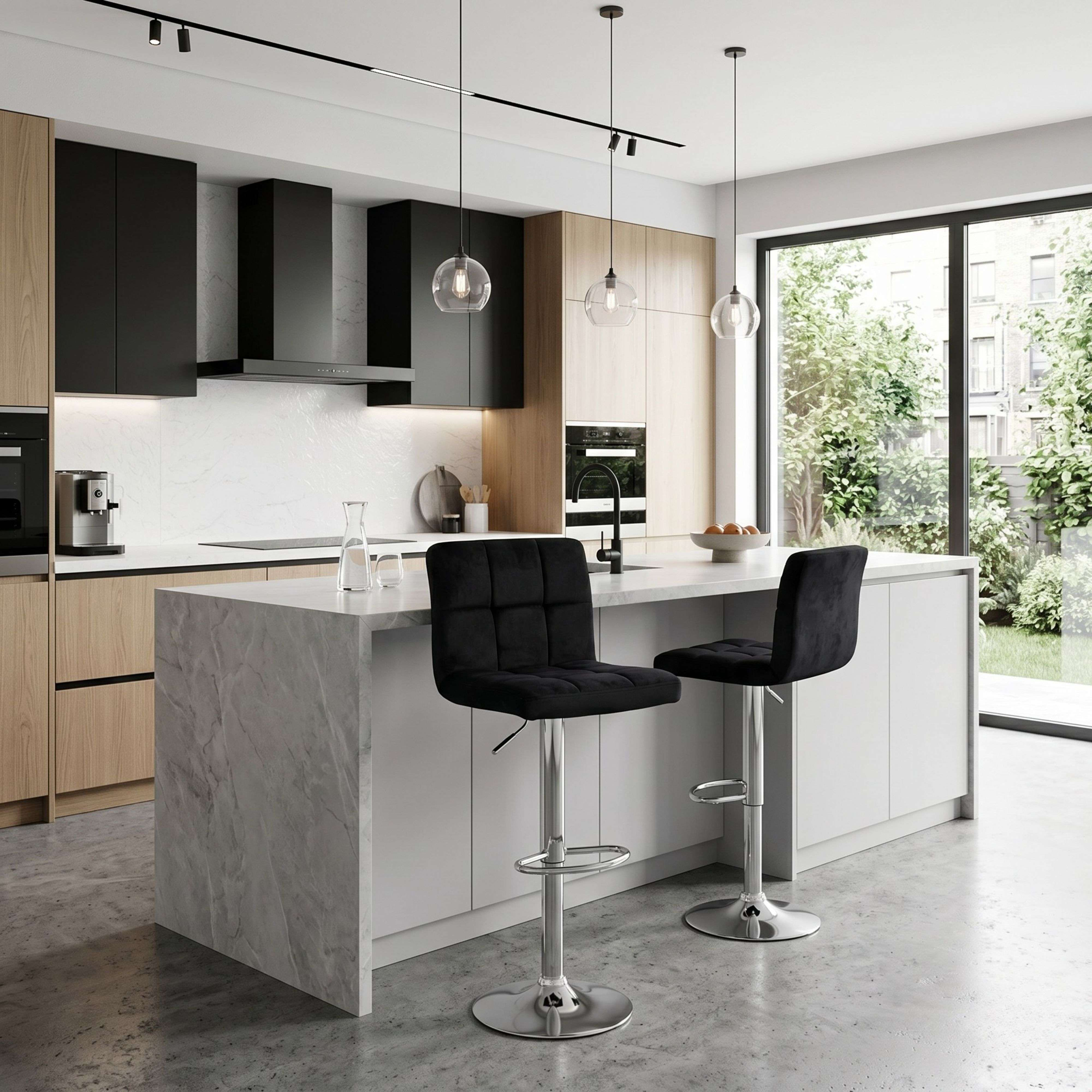 Cocina moderna con isla de mármol, taburetes altos negros y vista al exterior.
