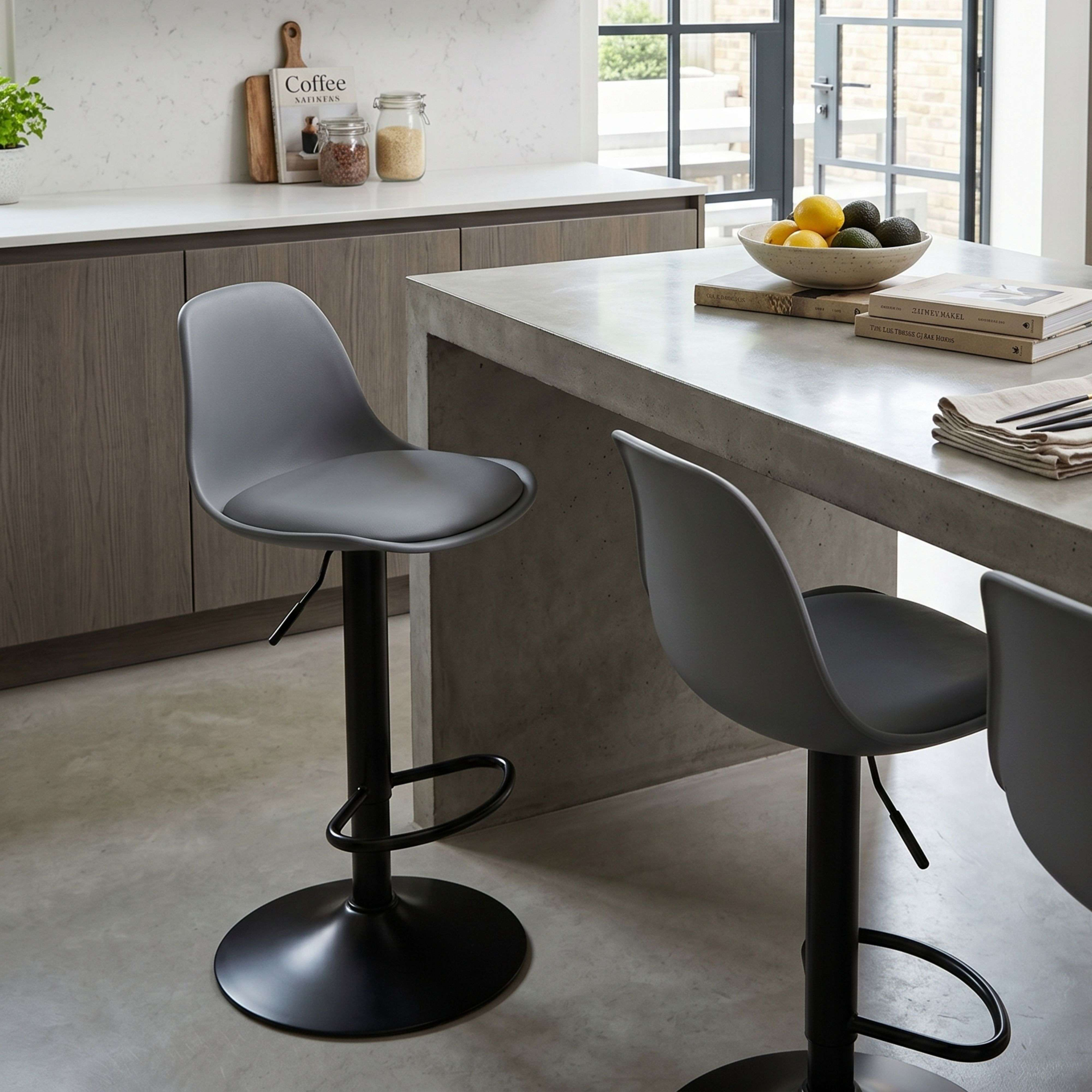 Taburetes de bar grises en cocina moderna con encimera de hormigón y madera.