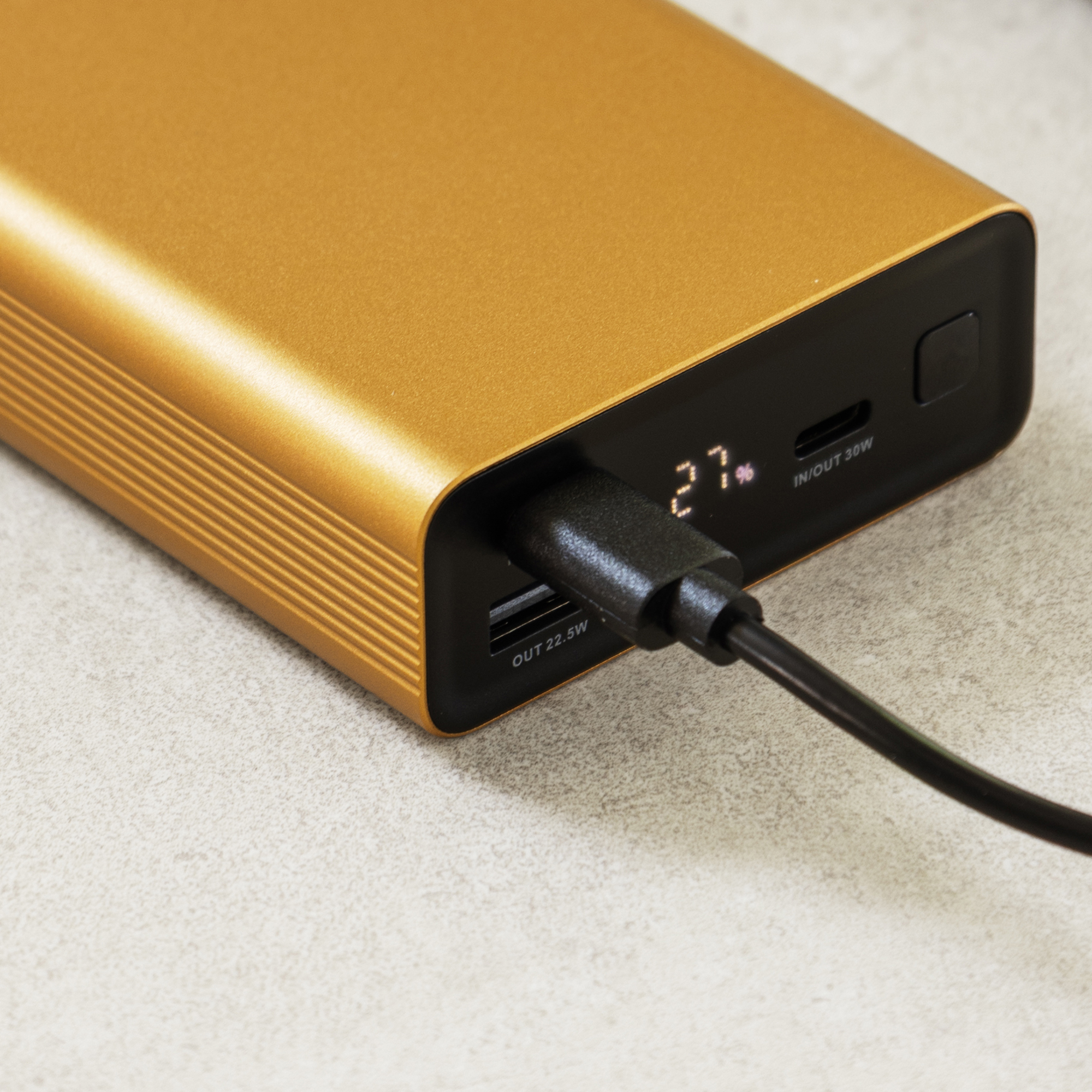 Gold power bank with USB-C cable and 27% battery indicator.