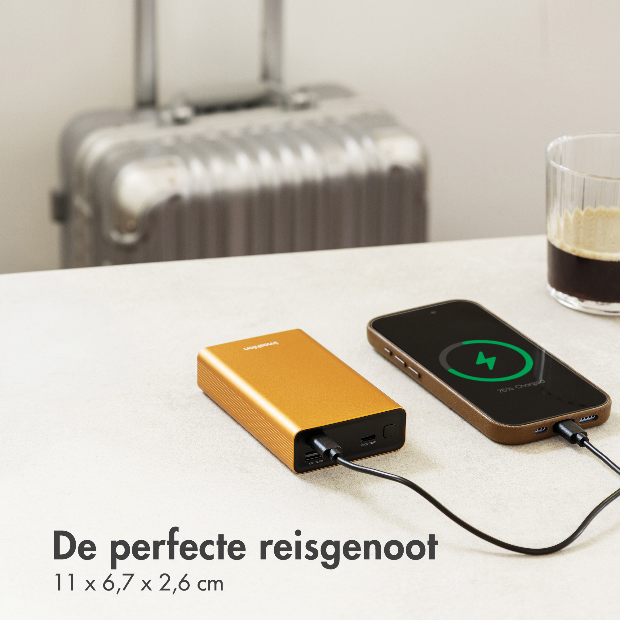 An orange power bank charges a smartphone, which is 75% charged.