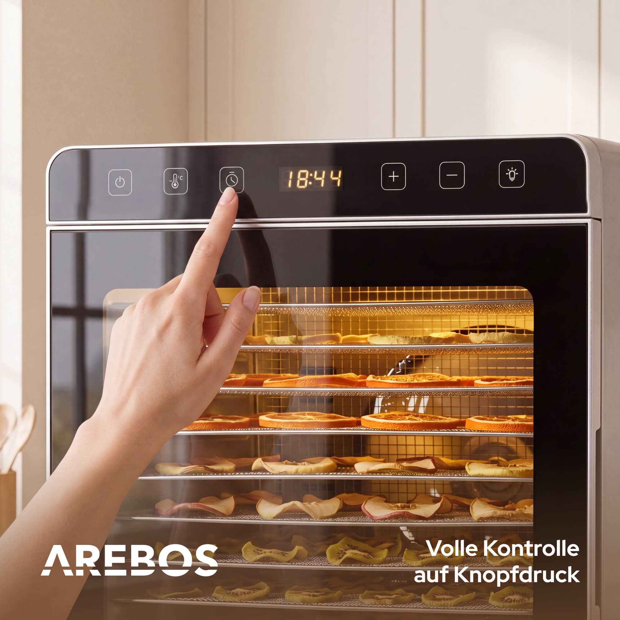 Eine Hand drückt auf die Timer-Taste eines Dörrgeräts mit Fruchtscheiben.