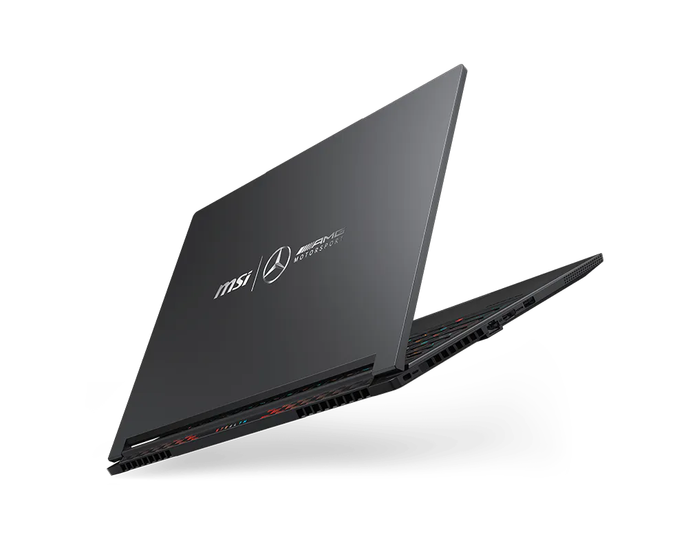 Un laptop MSI grigio scuro con loghi Mercedes-AMG Petronas F1 Team, aperto su sfondo nero.