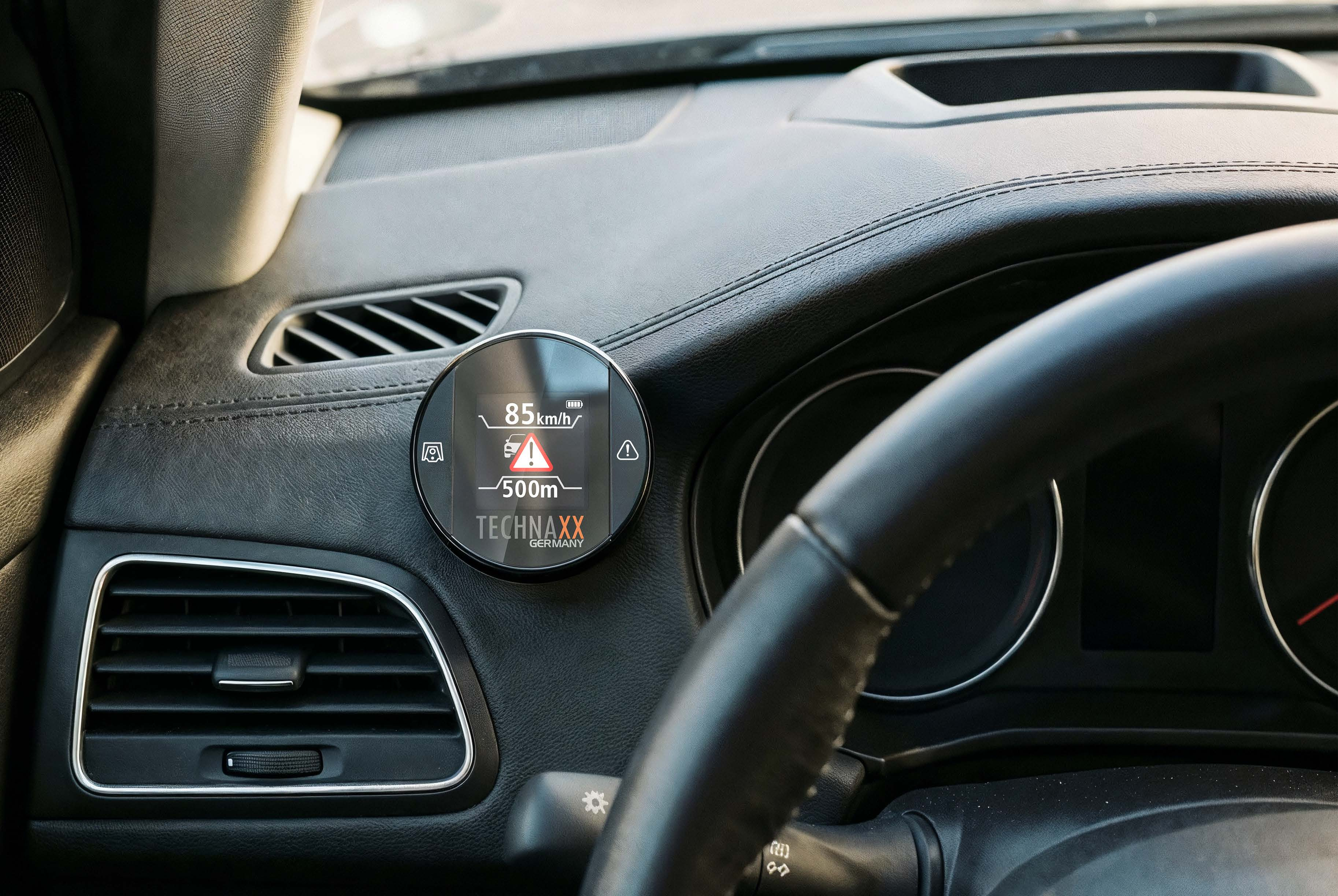 Digitalanzeige im Auto zeigt 85 km/h, 500m und Warnsymbole.