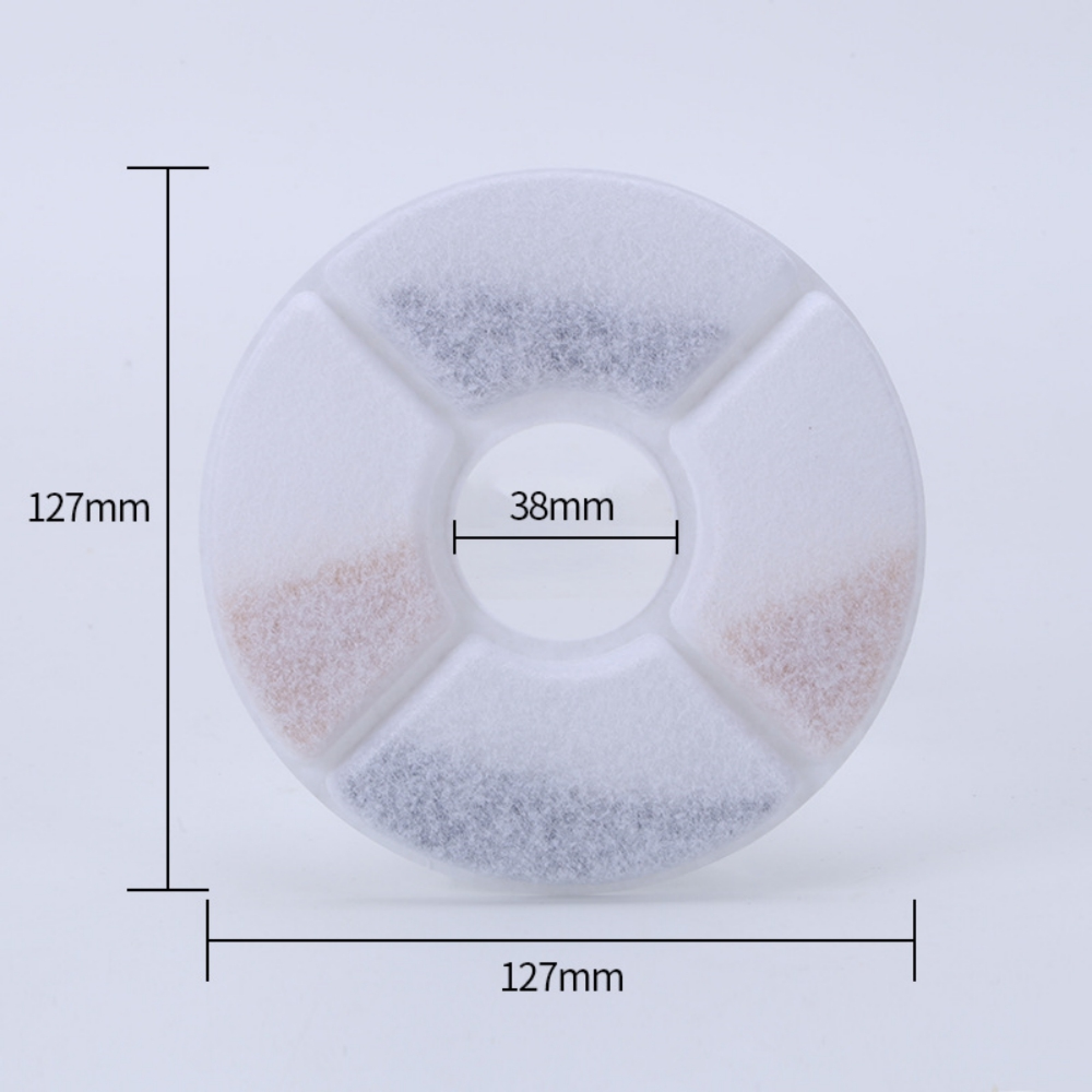 Runder Filter mit vier Fächern: zwei mit schwarzen Granulaten, zwei mit hellbraunen Granulaten.